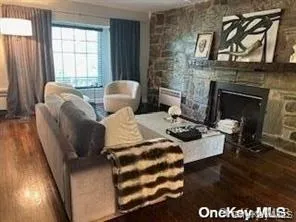 Living room with dark wood-type flooring and a fireplace Living room with dark wood-type flooring and a fireplace