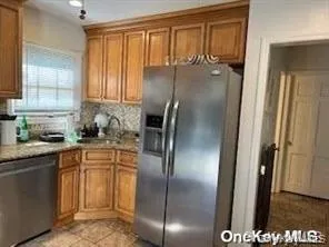 Kitchen with brown cabinets, stainless steel appliances, and backsplash Kitchen with brown cabinets, stainless steel appliances, and backsplash