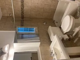 Bathroom with tile walls, shower / bathtub combination with curtain, and tile patterned floors Bathroom with tile walls, shower / bathtub combination with curtain, and tile patterned floors