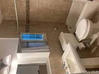 Bathroom with tile walls, shower / bathtub combination with curtain, and tile patterned floors Bathroom with tile walls, shower / bathtub combination with curtain, and tile patterned floors