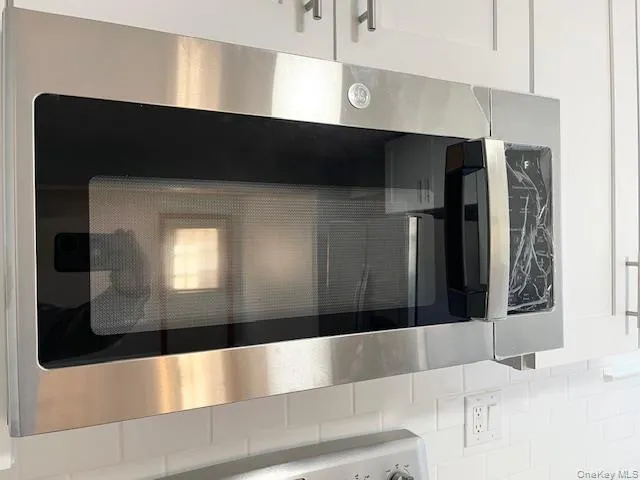 Kitchen view of stainless steel microwave and white cabinetry Kitchen view of stainless steel microwave and white cabinetry