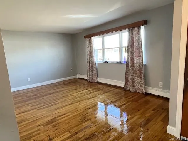 Unfurnished room featuring dark wood-type flooring and baseboards Unfurnished room featuring dark wood-type flooring and baseboards