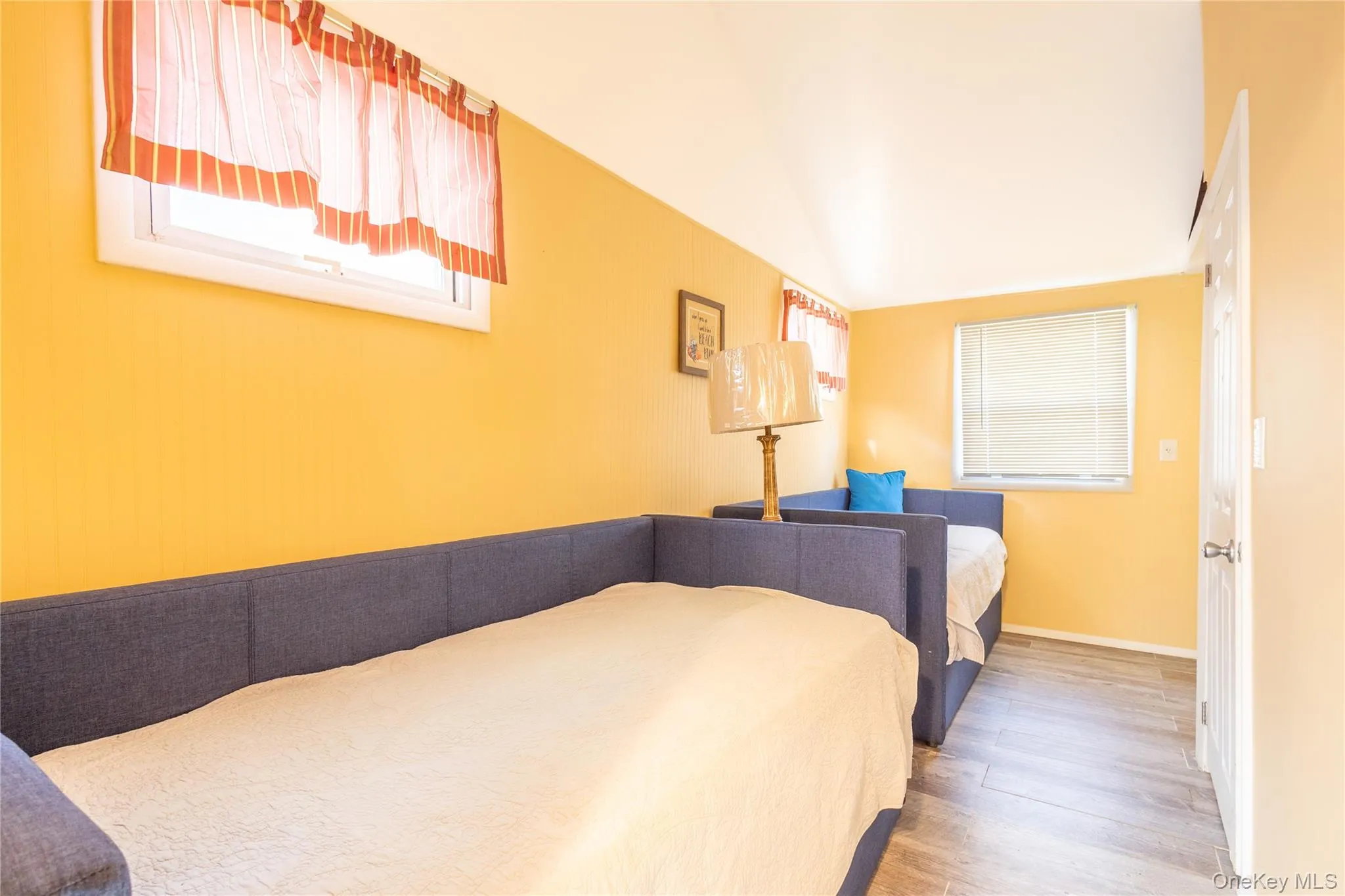 Bedroom featuring multiple windows and wood finished floors Bedroom featuring multiple windows and wood finished floors