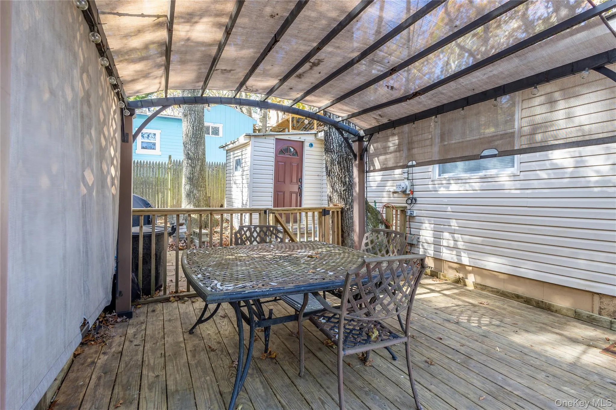 Wooden terrace featuring outdoor dining space and a shed Wooden terrace featuring outdoor dining space and a shed