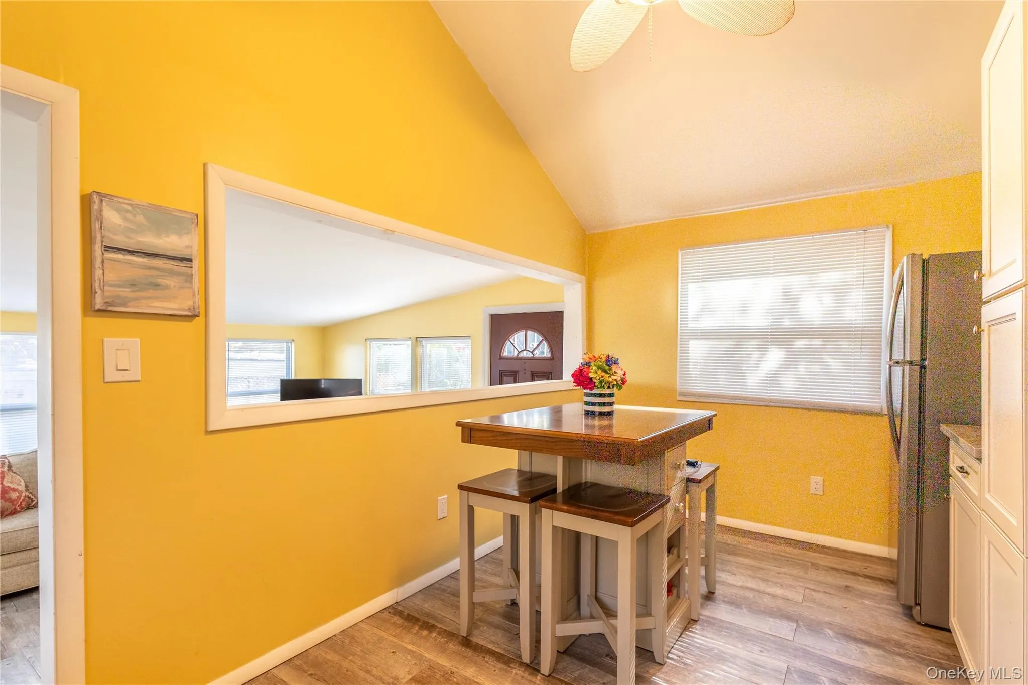 Dining area featuring light wood-style flooring, plenty of natural light, lofted ceiling, and ceiling fan Dining area featuring light wood-style flooring, plenty of natural light, lofted ceiling, and ceiling fan