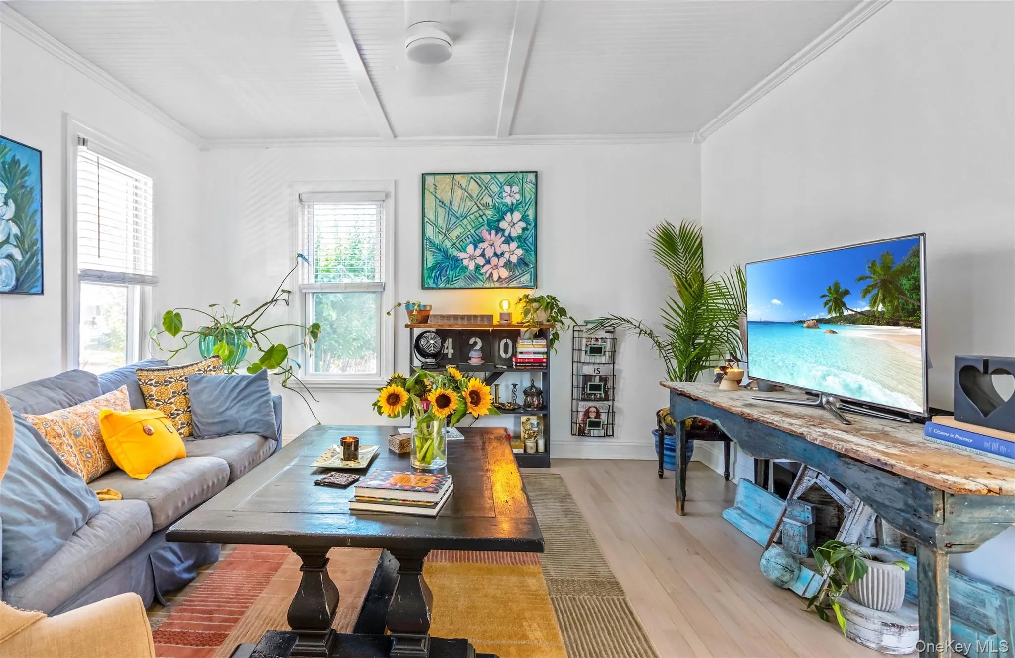 Living room with wood finished floors, beam ceiling, and crown molding Living room with wood finished floors, beam ceiling, and crown molding