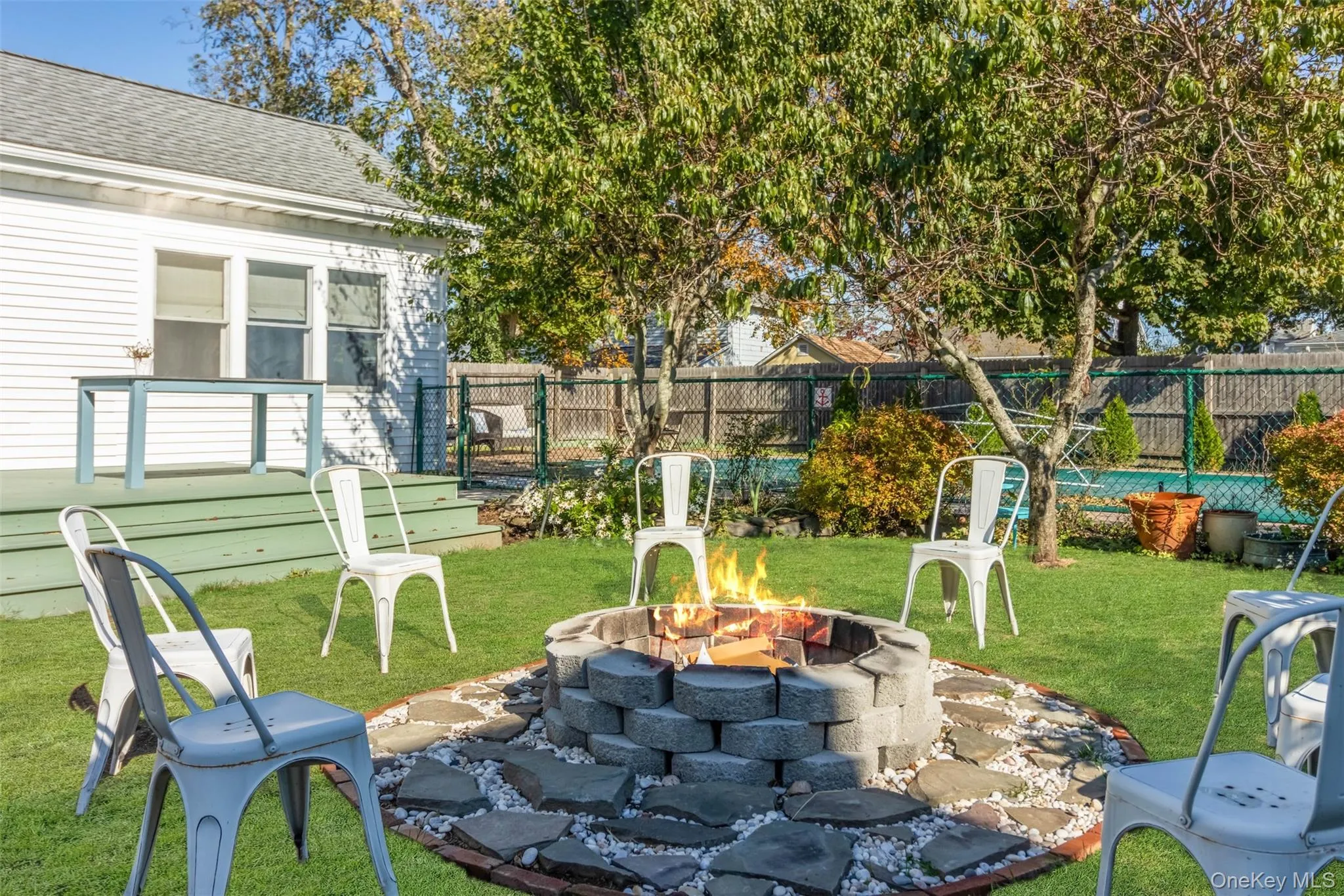 Fenced backyard featuring a patio area and an outdoor fire pit Fenced backyard featuring a patio area and an outdoor fire pit