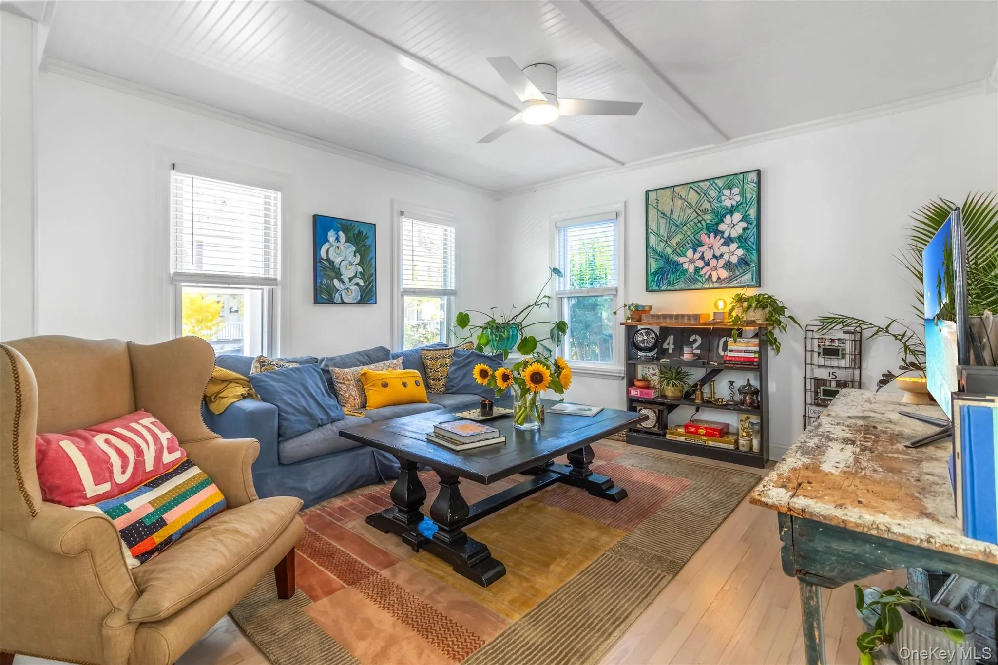 Living room with light wood-style floors, ceiling fan, and ornamental molding Living room with light wood-style floors, ceiling fan, and ornamental molding