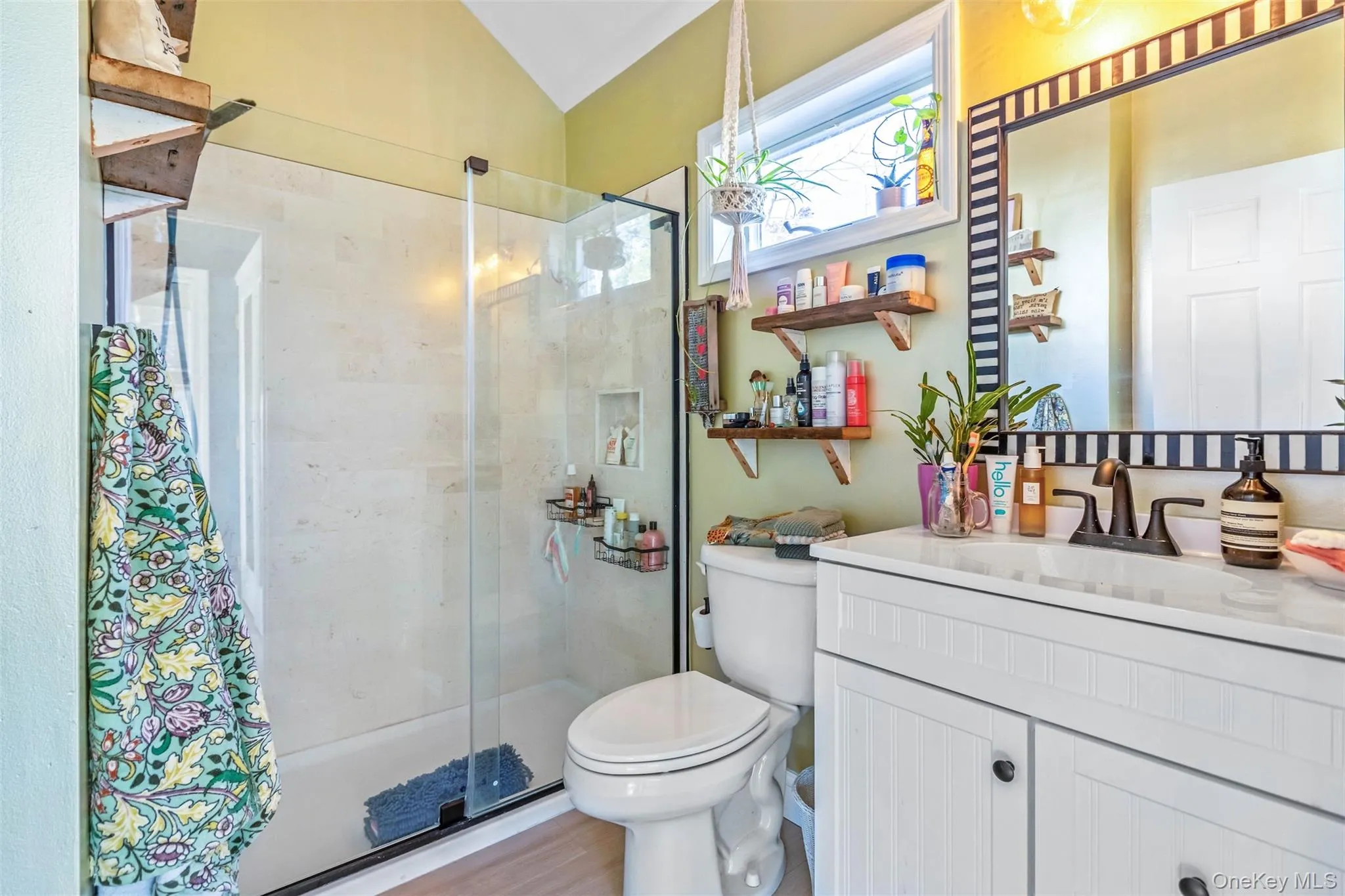 Full bathroom with a shower stall, vanity, and light wood-style flooring Full bathroom with a shower stall, vanity, and light wood-style flooring