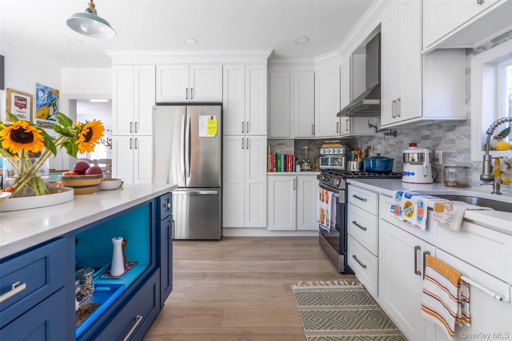 Kitchen featuring blue cabinets, stainless steel appliances, white cabinetry, wall chimney range hood, and recessed lighting Kitchen featuring blue cabinets, stainless steel appliances, white cabinetry, wall chimney range hood, and recessed lighting