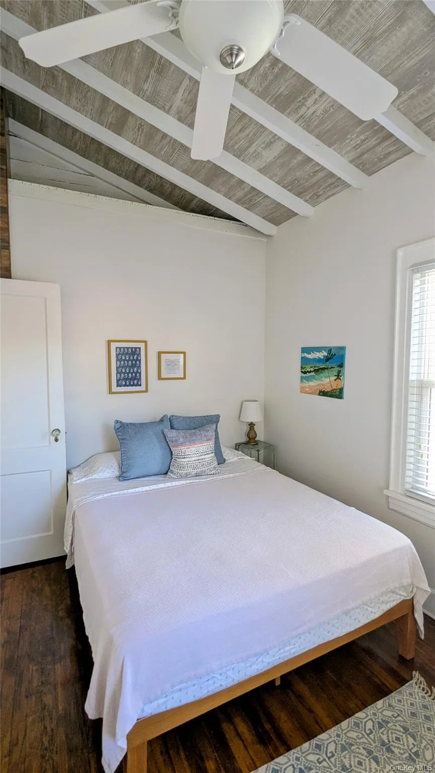 Bedroom 2 with dark wood finished floors and vaulted ceiling Bedroom 2 with dark wood finished floors and vaulted ceiling