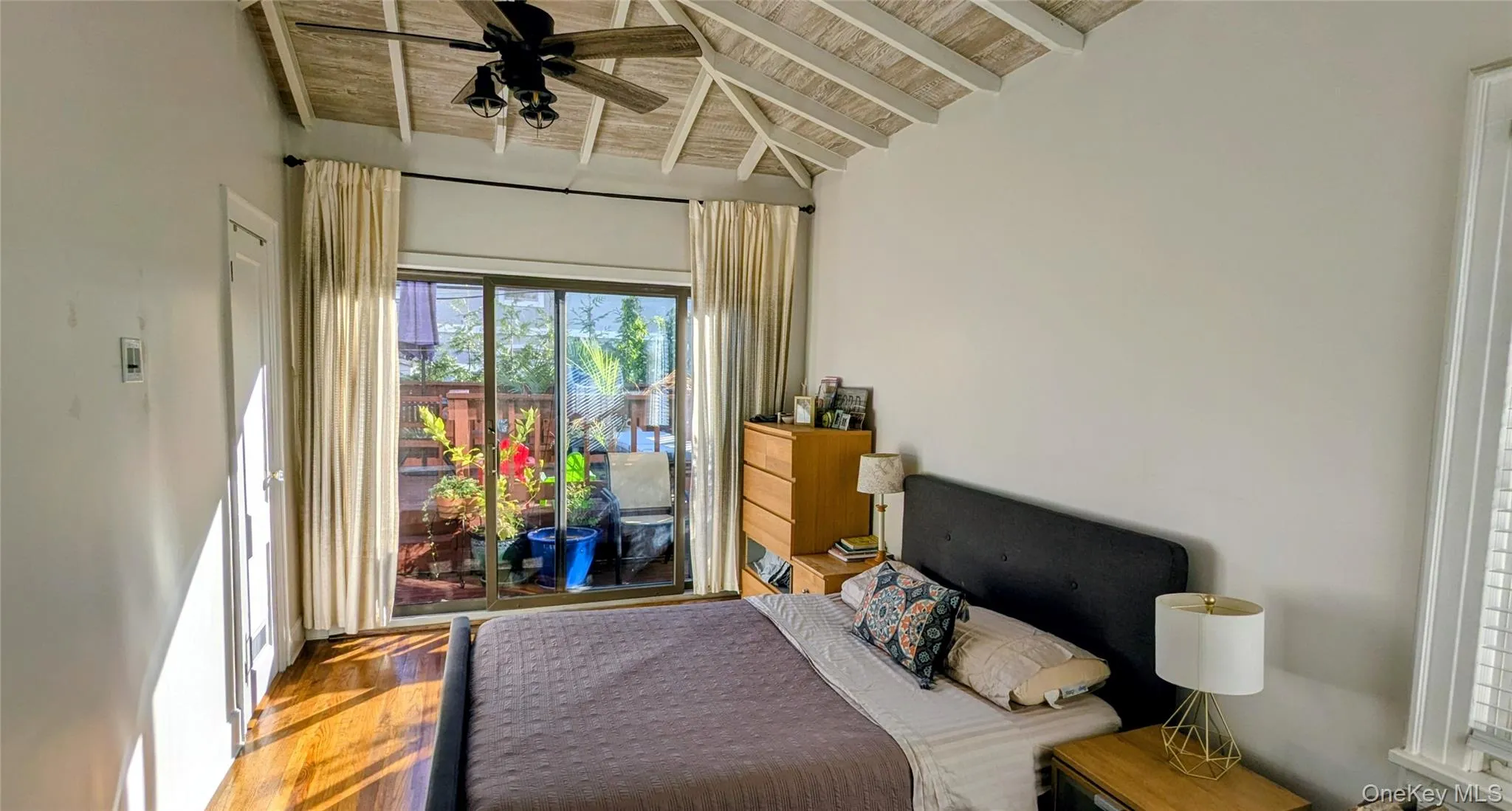 Master bedroom featuring access to deck, with fan and vaulted ceiling Master bedroom featuring access to deck, with fan and vaulted ceiling