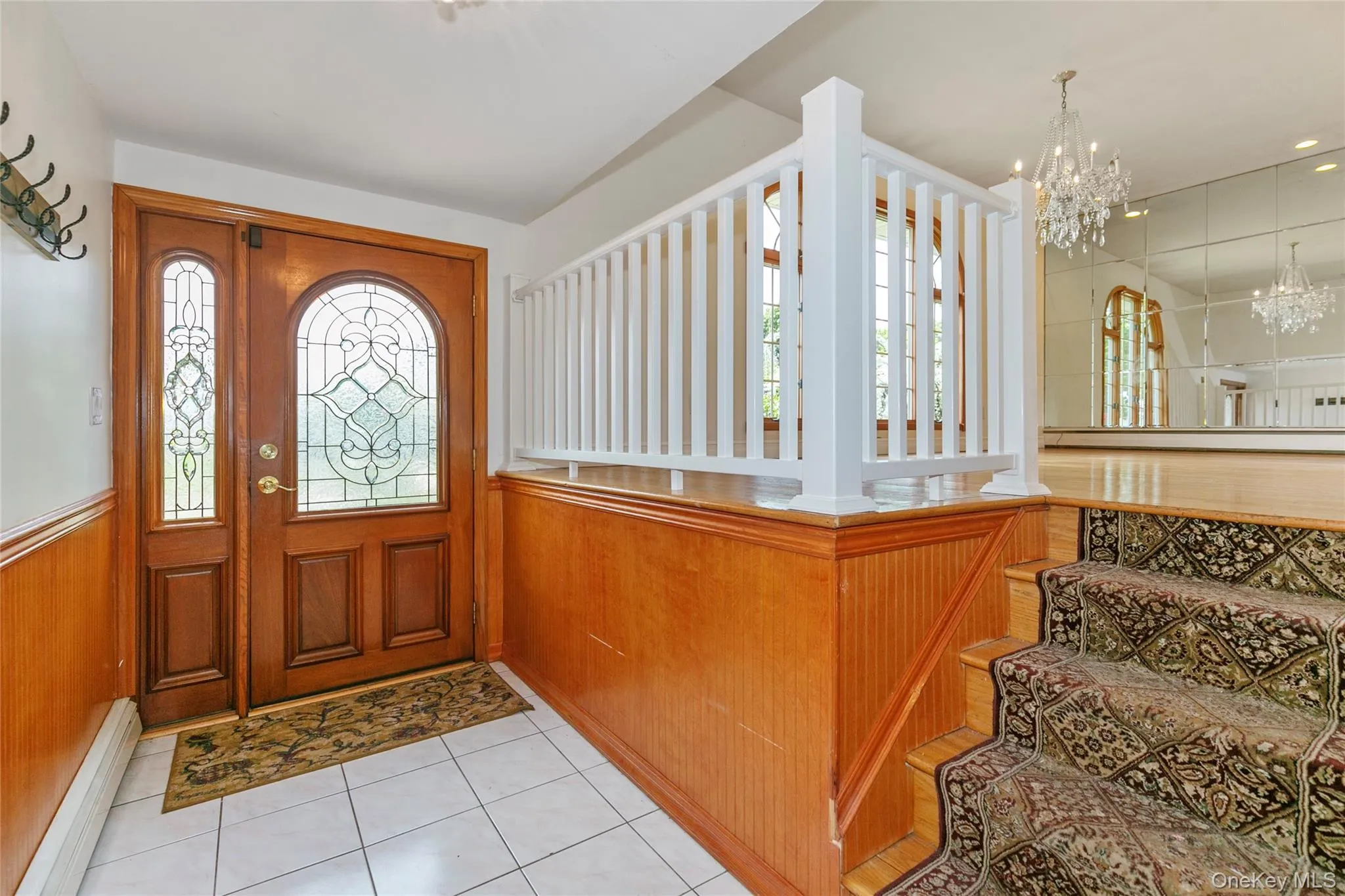 Foyer with plenty of natural light, a baseboard heating unit, light tile patterned flooring, and a chandelier Foyer with plenty of natural light, a baseboard heating unit, light tile patterned flooring, and a chandelier