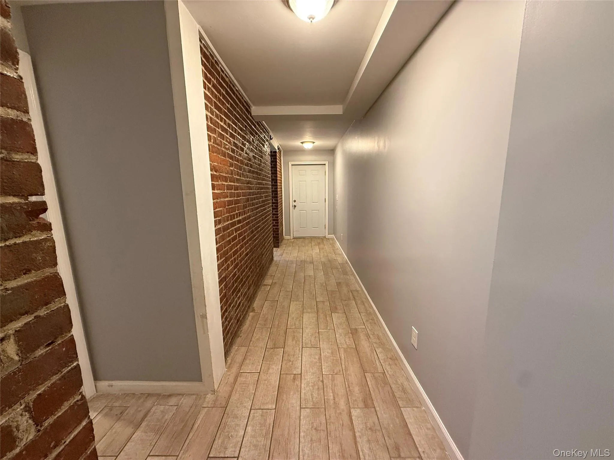 Hall with brick wall and light wood-type flooring Hall with brick wall and light wood-type flooring
