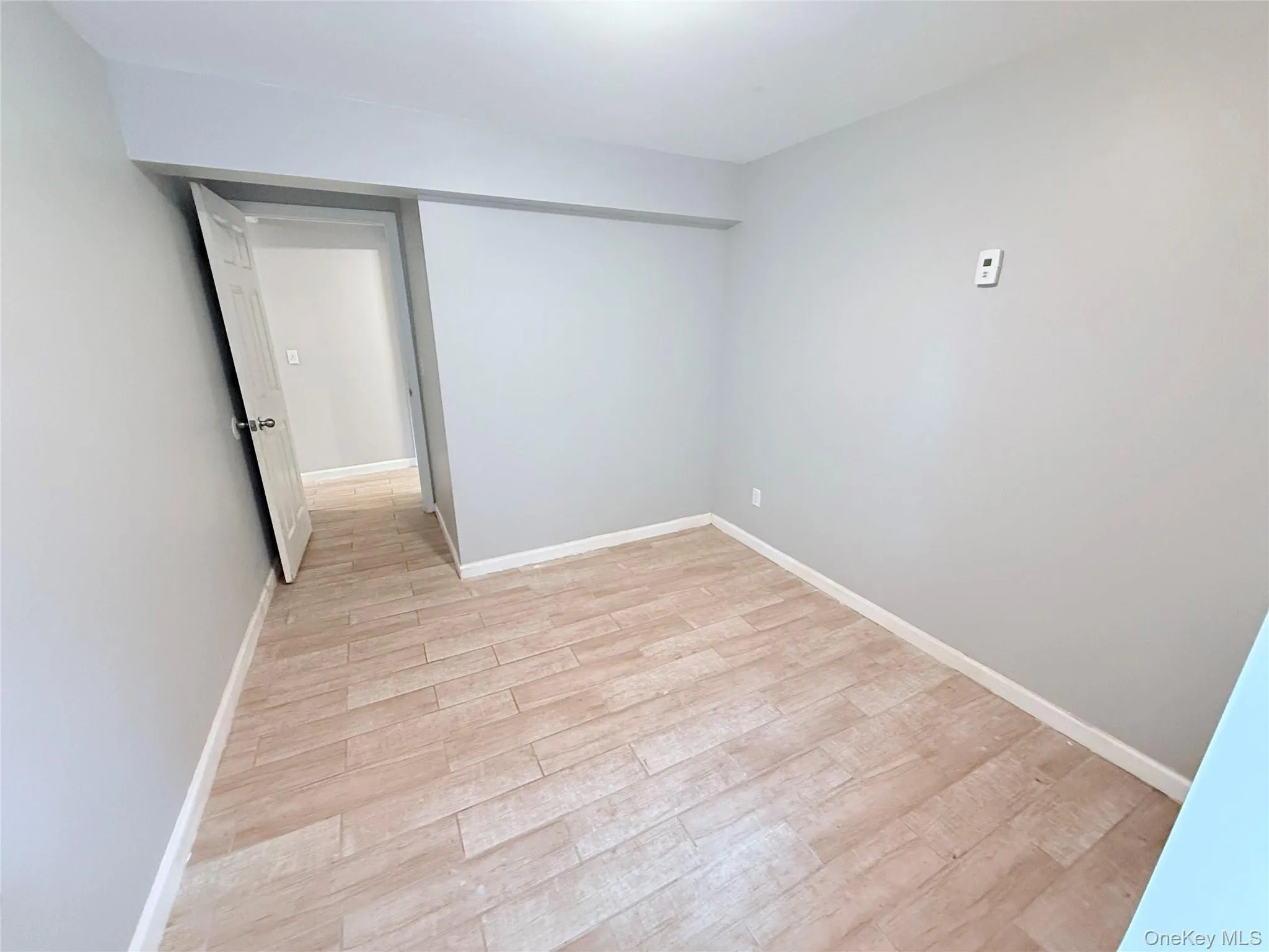 Unfurnished room featuring light wood-style flooring and baseboards Unfurnished room featuring light wood-style flooring and baseboards