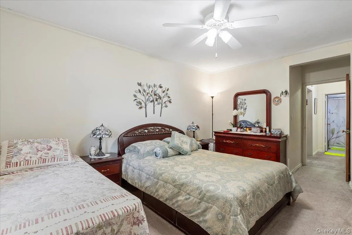 Carpeted bedroom with ceiling fan and ornamental molding Carpeted bedroom with ceiling fan and ornamental molding