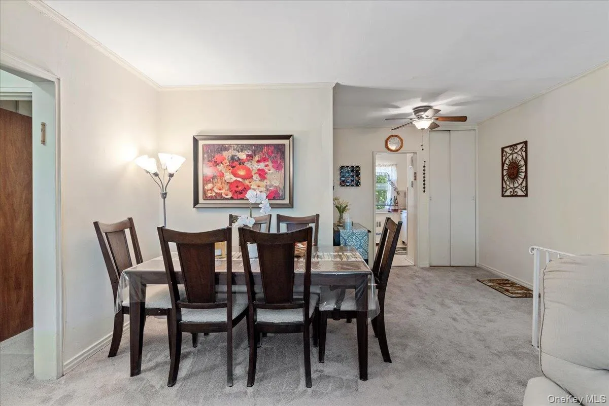Dining room with light carpet, crown molding, and a ceiling fan Dining room with light carpet, crown molding, and a ceiling fan