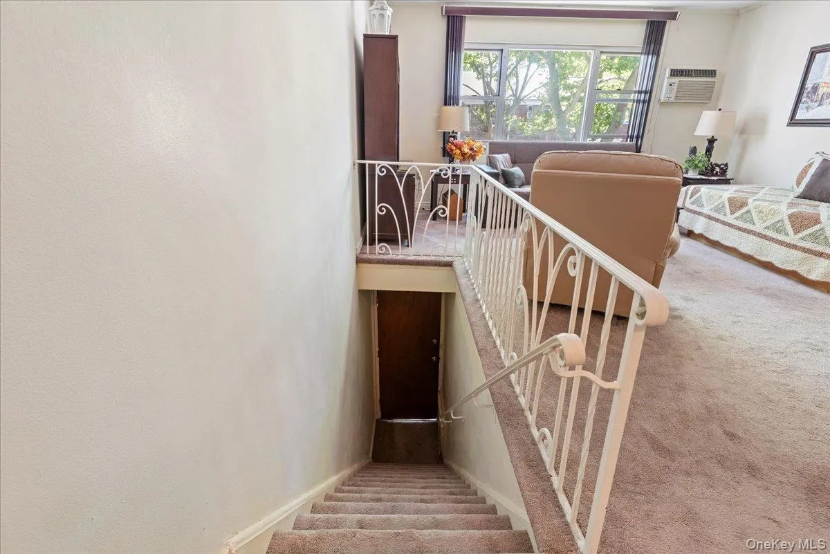 Stairway featuring carpet floors and a wall mounted AC Stairway featuring carpet floors and a wall mounted AC
