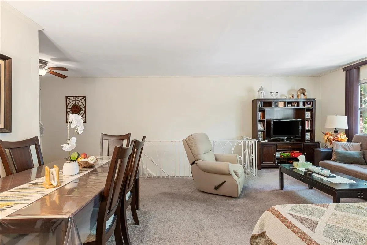 Carpeted living area featuring a ceiling fan Carpeted living area featuring a ceiling fan
