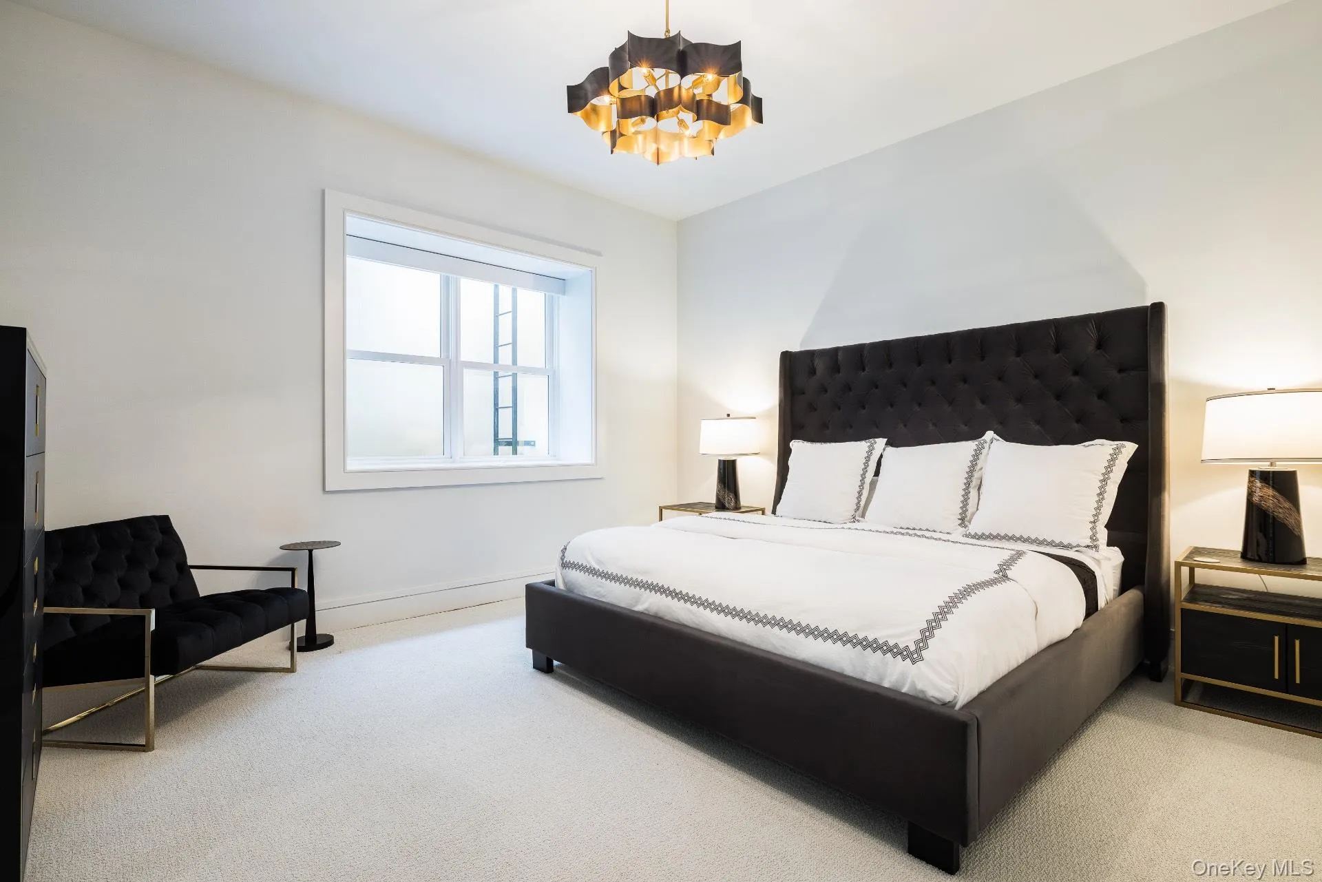 Carpeted bedroom with a chandelier and baseboards Carpeted bedroom with a chandelier and baseboards