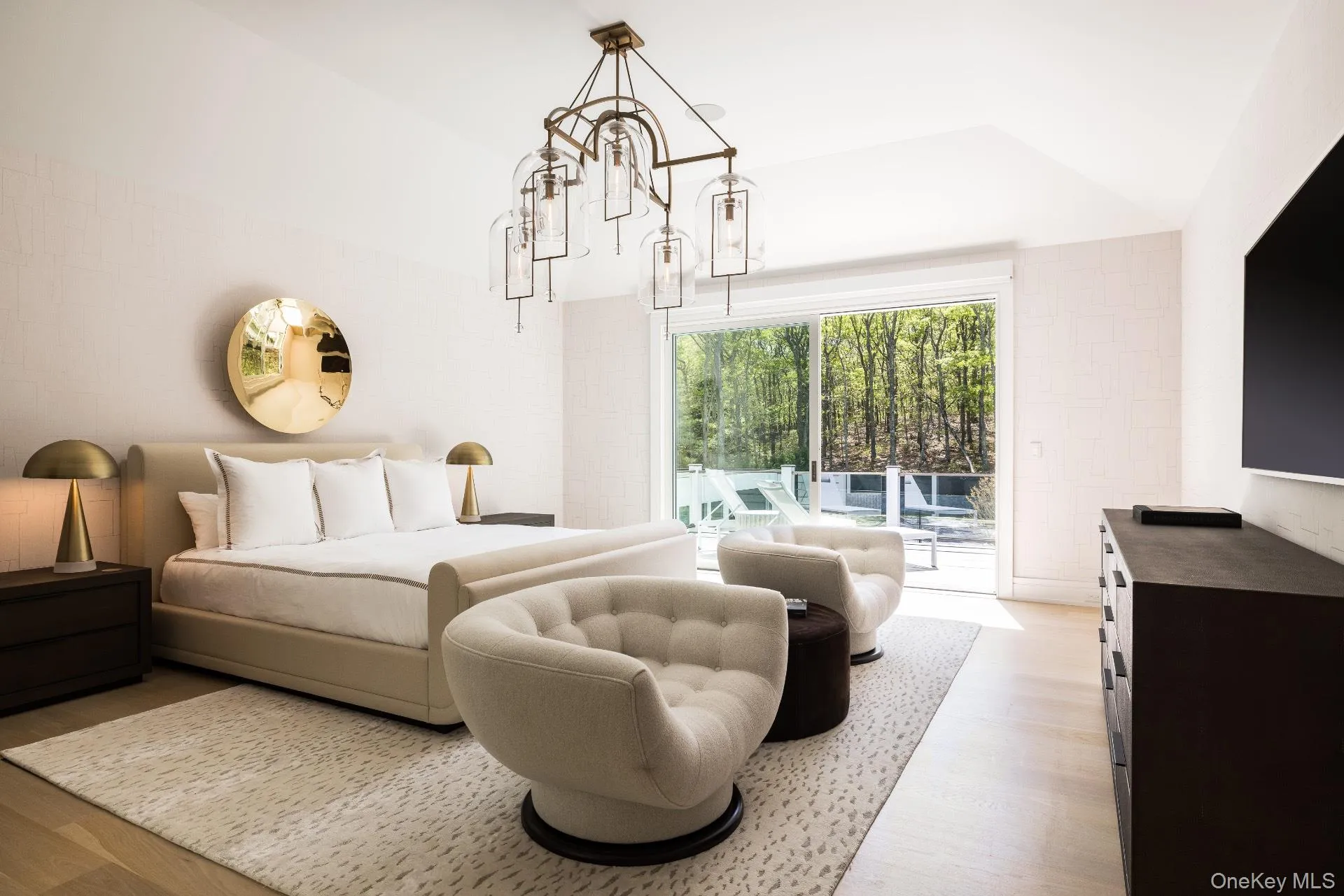 Bedroom featuring wood finished floors, lofted ceiling, access to exterior, and a chandelier Bedroom featuring wood finished floors, lofted ceiling, access to exterior, and a chandelier