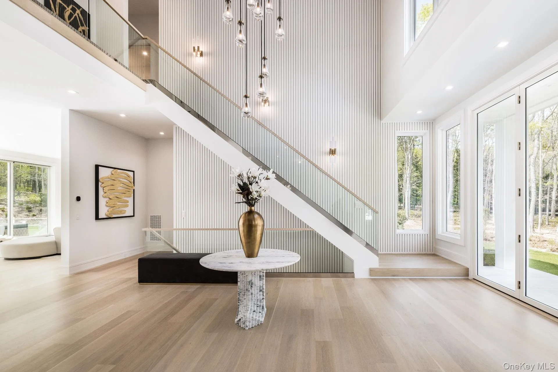 Foyer featuring a high ceiling, wood finished floors, recessed lighting, and stairway Foyer featuring a high ceiling, wood finished floors, recessed lighting, and stairway