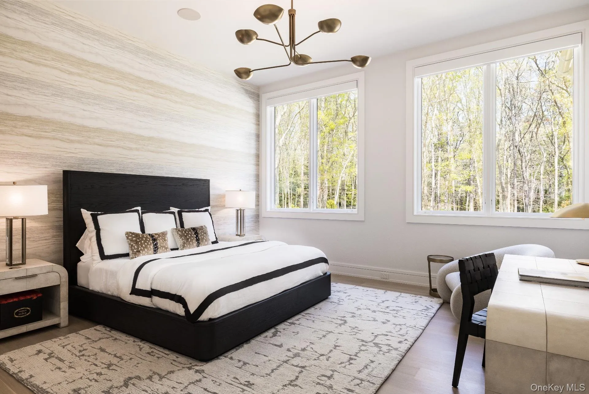Bedroom with wood finished floors, multiple windows, a chandelier, and an accent wall Bedroom with wood finished floors, multiple windows, a chandelier, and an accent wall