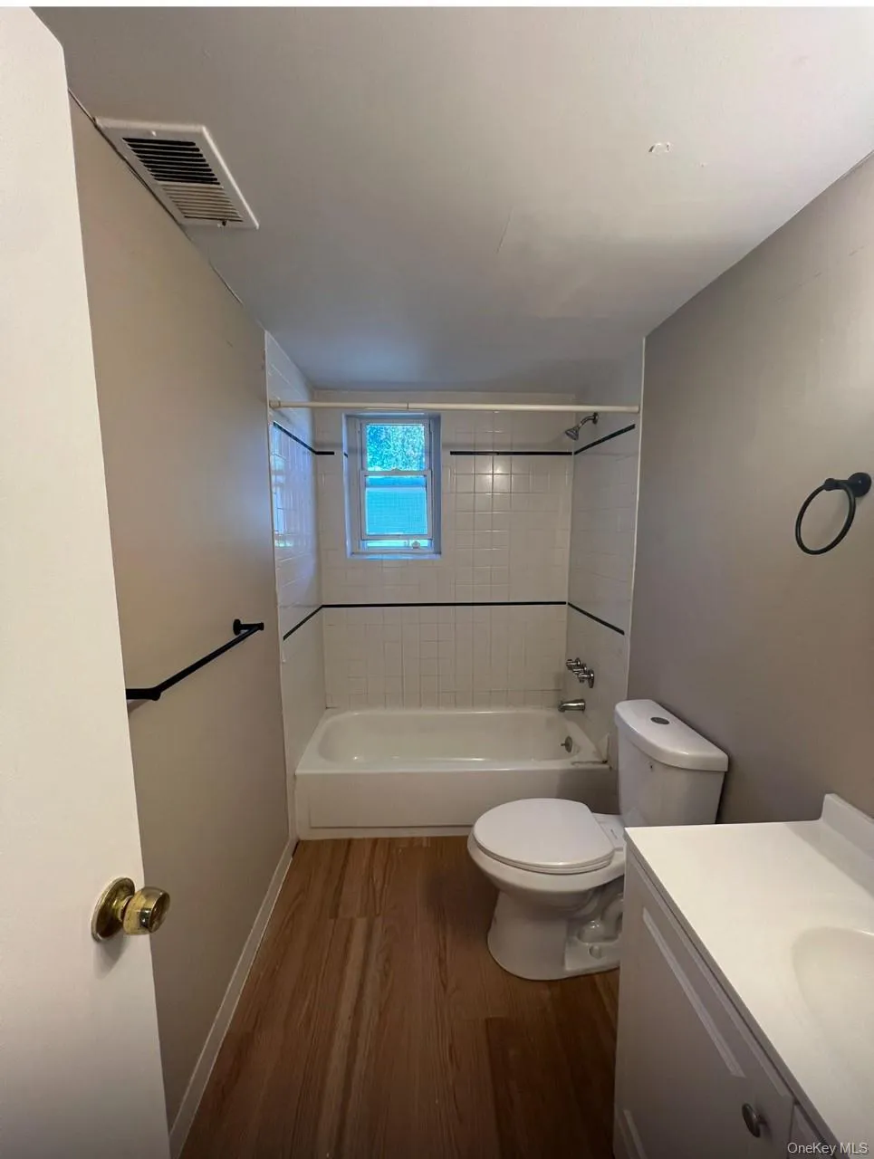 Bathroom with dark wood-style floors, bathing tub / shower combination, and vanity Bathroom with dark wood-style floors, bathing tub / shower combination, and vanity