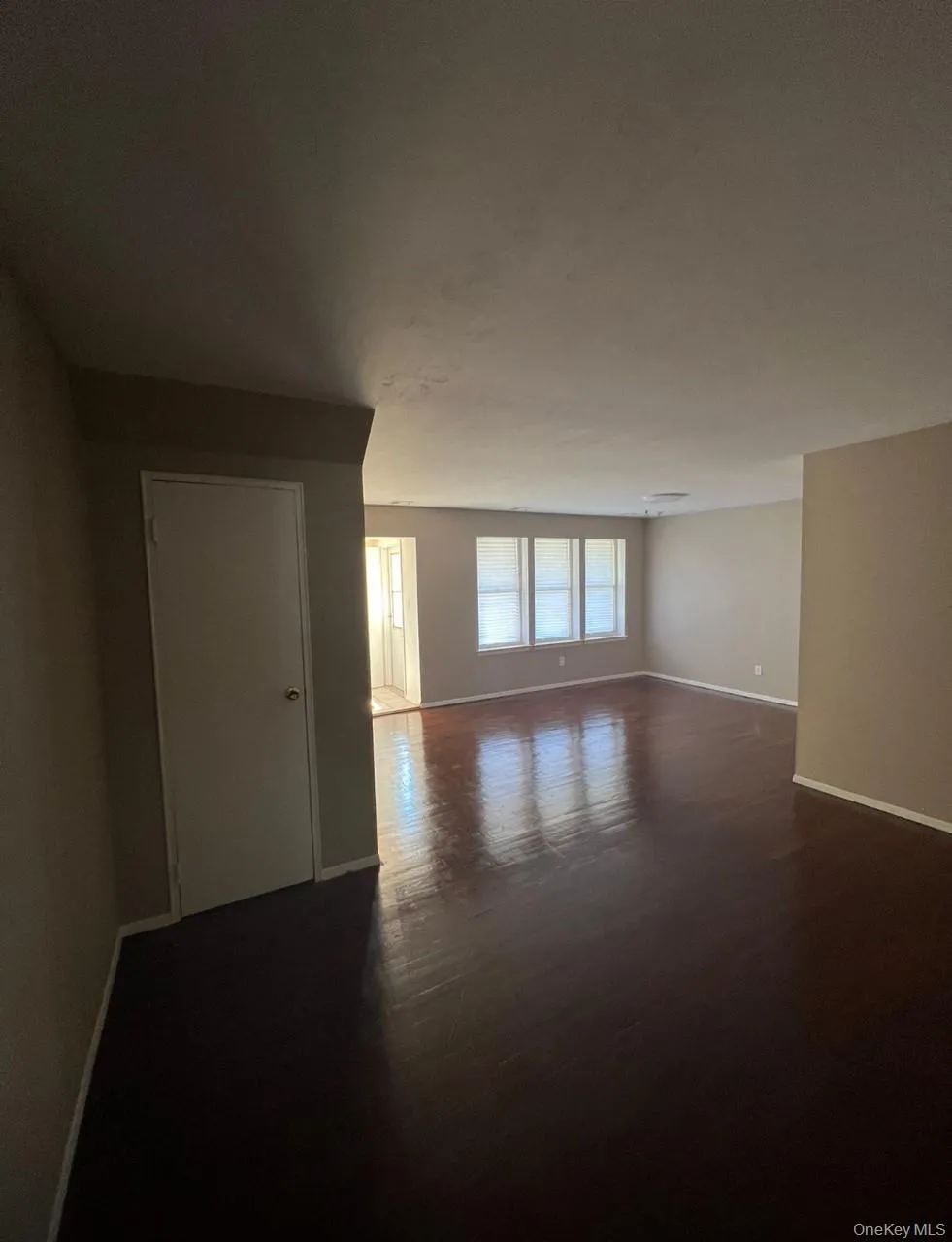Spare room featuring baseboards and dark wood-type flooring Spare room featuring baseboards and dark wood-type flooring