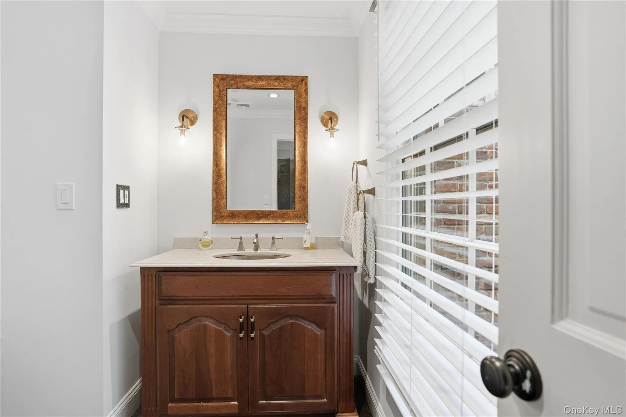 Half bath featuring crown molding and vanity Half bath featuring crown molding and vanity