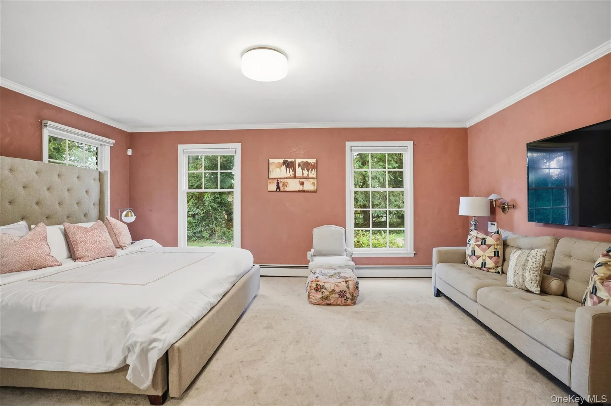 Bedroom featuring carpet, multiple windows, crown molding, and baseboard heating Bedroom featuring carpet, multiple windows, crown molding, and baseboard heating