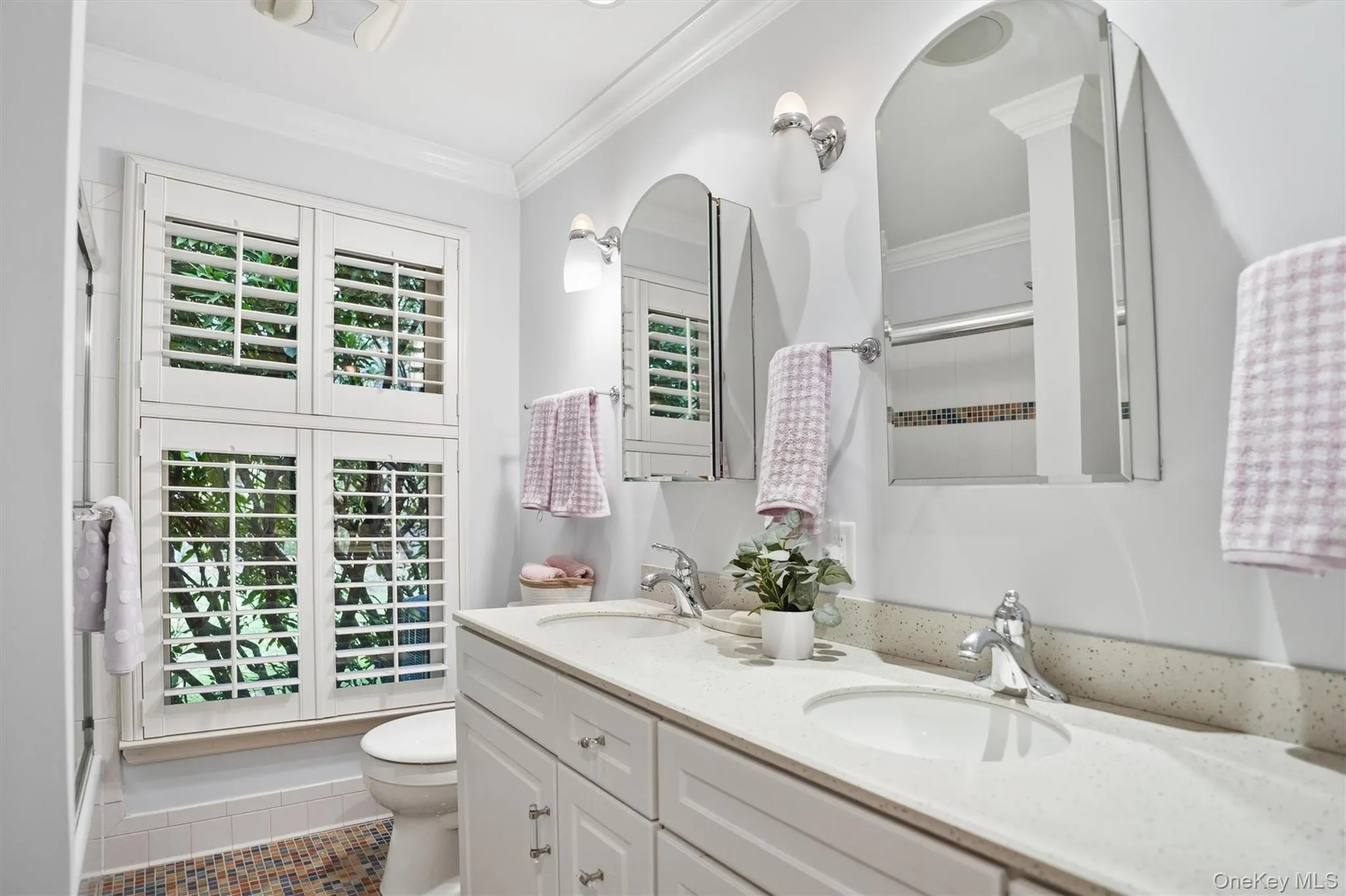 Bathroom featuring ornamental molding, double vanity, tile patterned floors, and a shower with door Bathroom featuring ornamental molding, double vanity, tile patterned floors, and a shower with door