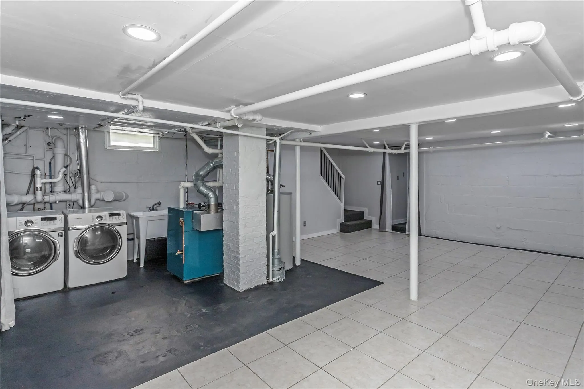Basement with separate washer and dryer, recessed lighting, a sink, and stairway Basement with separate washer and dryer, recessed lighting, a sink, and stairway