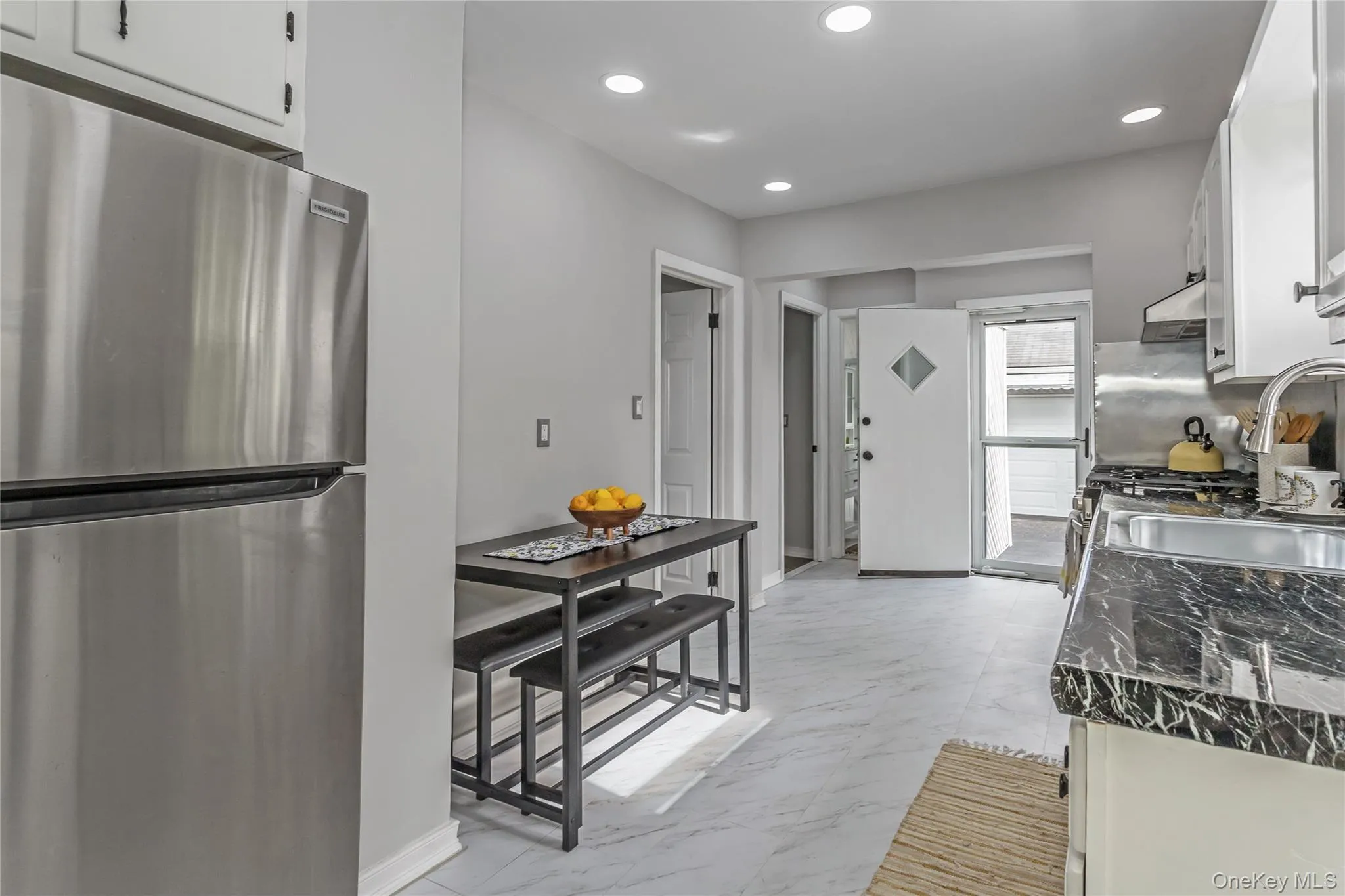 Kitchen featuring white cabinets, freestanding refrigerator, recessed lighting, and marble finish floor Kitchen featuring white cabinets, freestanding refrigerator, recessed lighting, and marble finish floor
