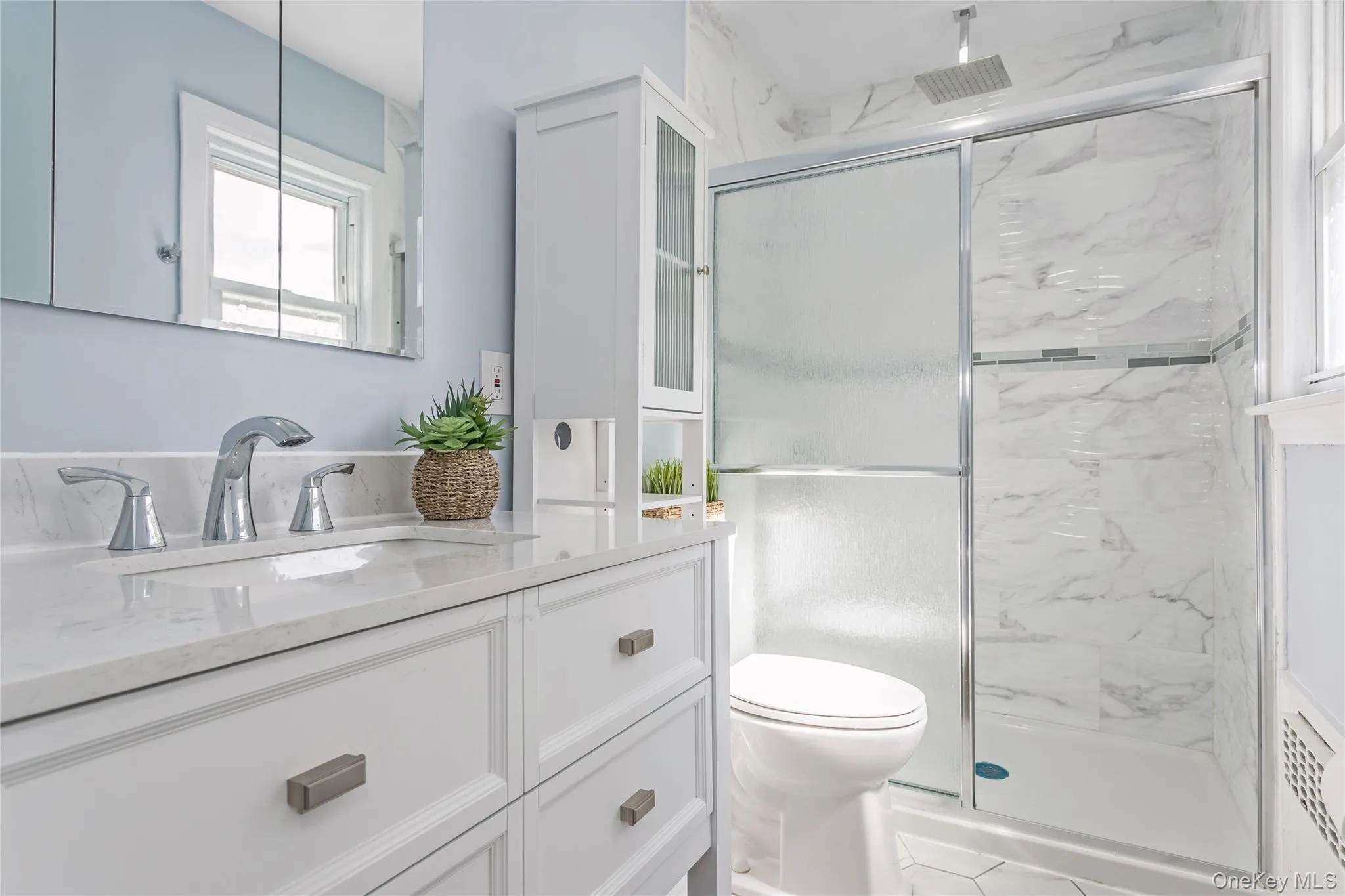Full bath featuring toilet, a marble finish shower, and vanity Full bath featuring toilet, a marble finish shower, and vanity
