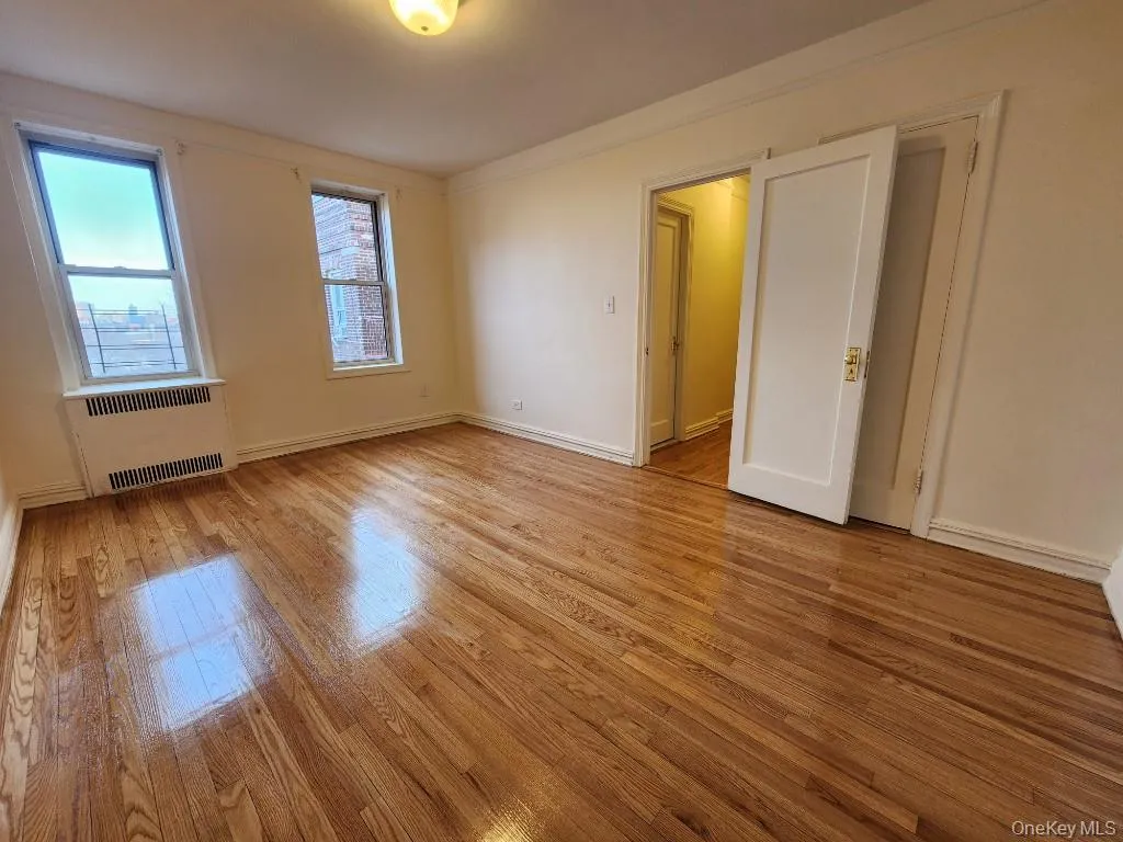 Spare room featuring light wood-style flooring and radiator heating unit Spare room featuring light wood-style flooring and radiator heating unit