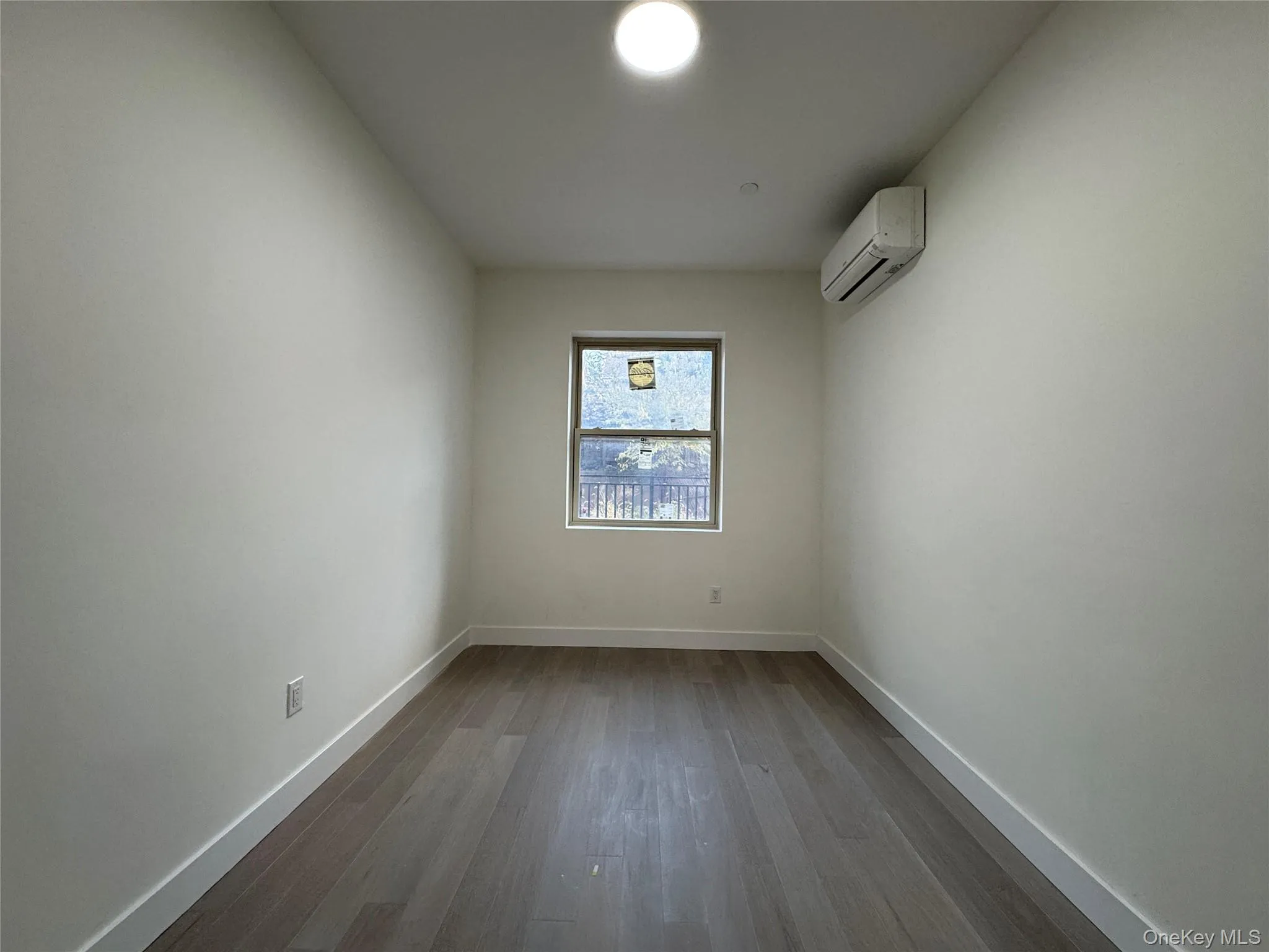 Spare room featuring dark wood-type flooring and a wall unit AC Spare room featuring dark wood-type flooring and a wall unit AC