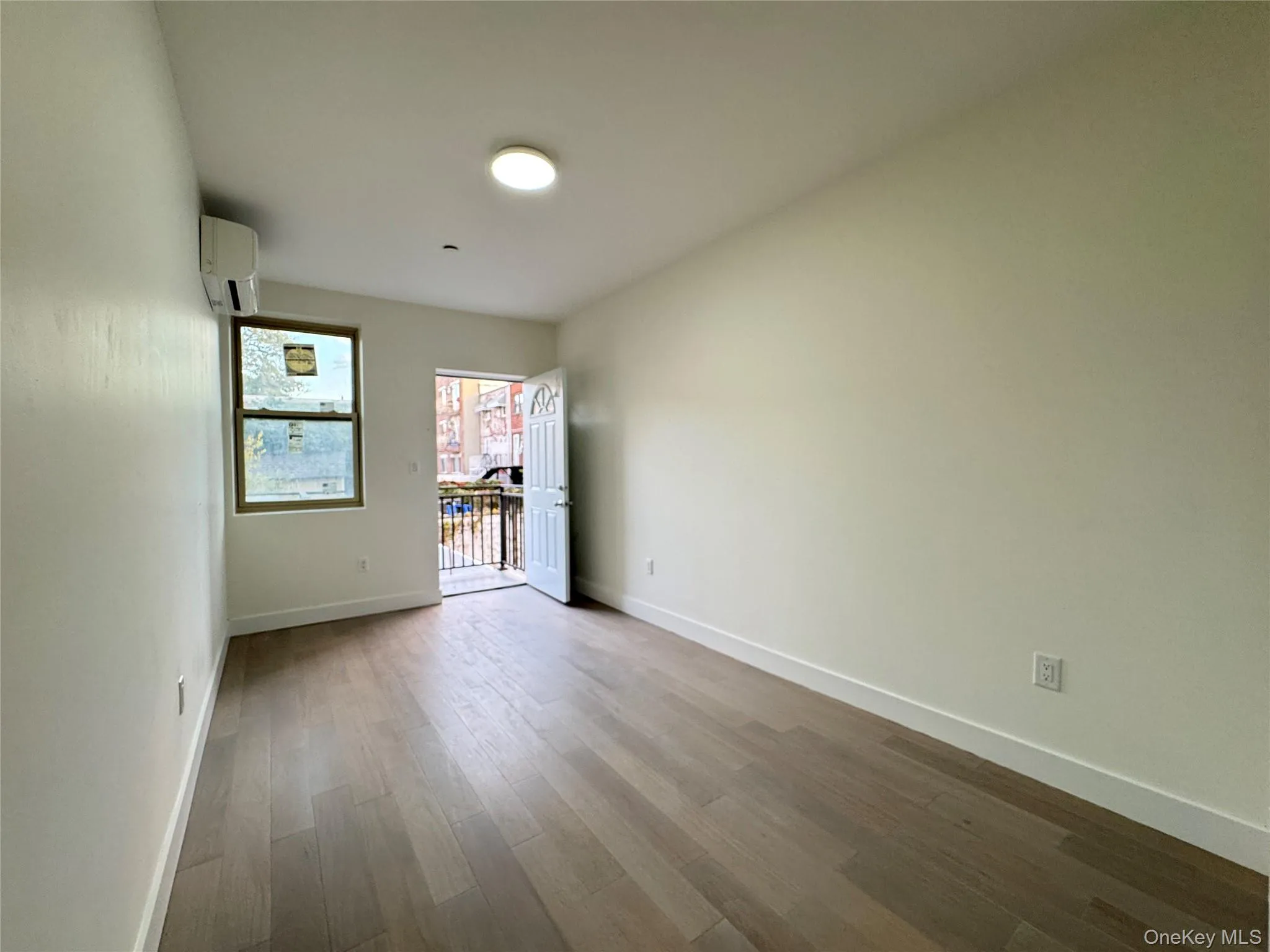 Unfurnished room with wood finished floors and a wall mounted AC Unfurnished room with wood finished floors and a wall mounted AC