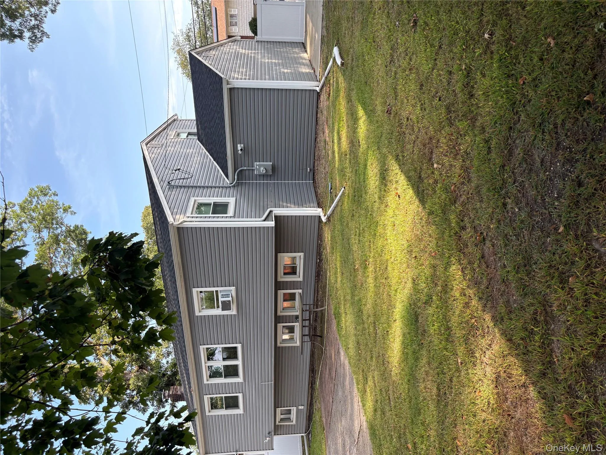 View of front of home with a front yard, roof with shingles, and a chimney View of front of home with a front yard, roof with shingles, and a chimney
