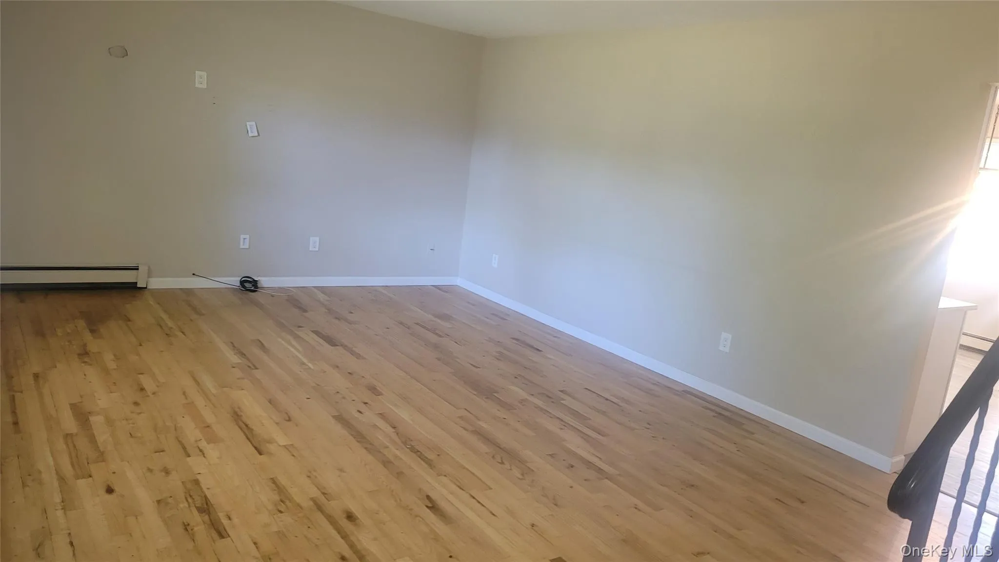 living room with light wood-type flooring and baseboard heating living room with light wood-type flooring and baseboard heating