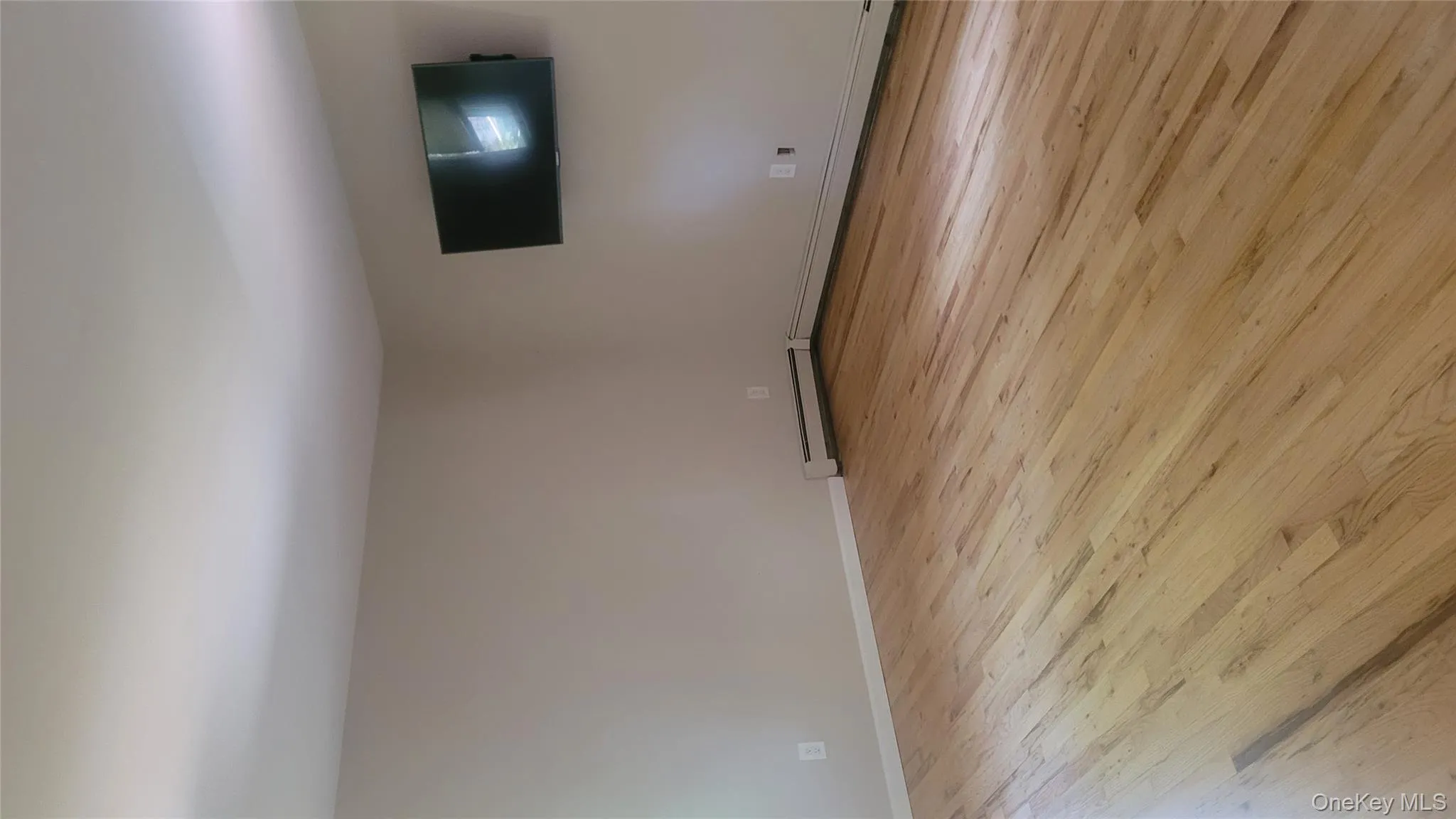 Empty room featuring light wood finished floors and baseboard heating Empty room featuring light wood finished floors and baseboard heating