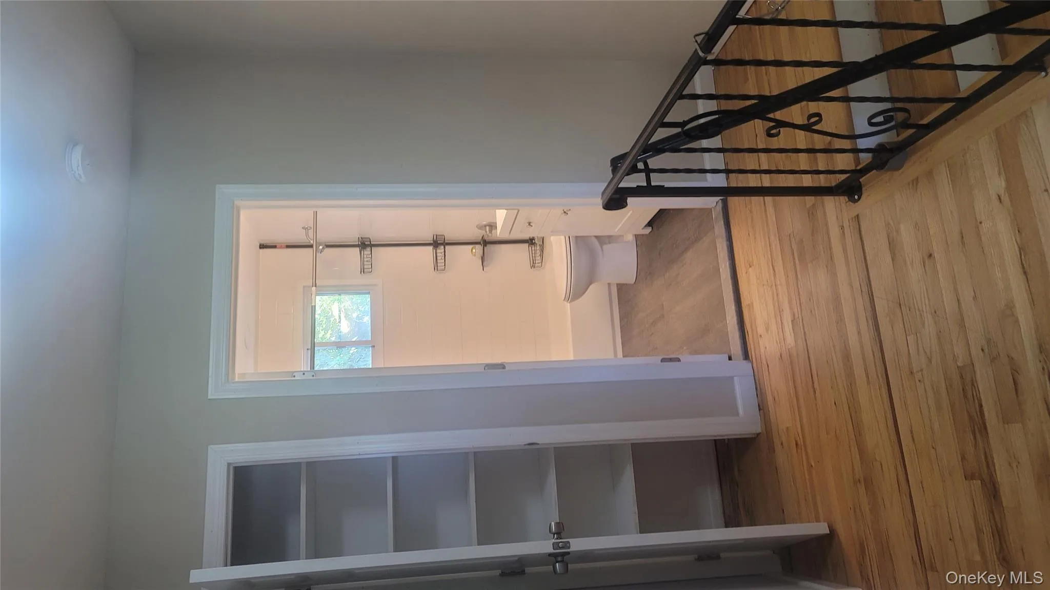 Hallway featuring light wood-type flooring and an upstairs landing Hallway featuring light wood-type flooring and an upstairs landing