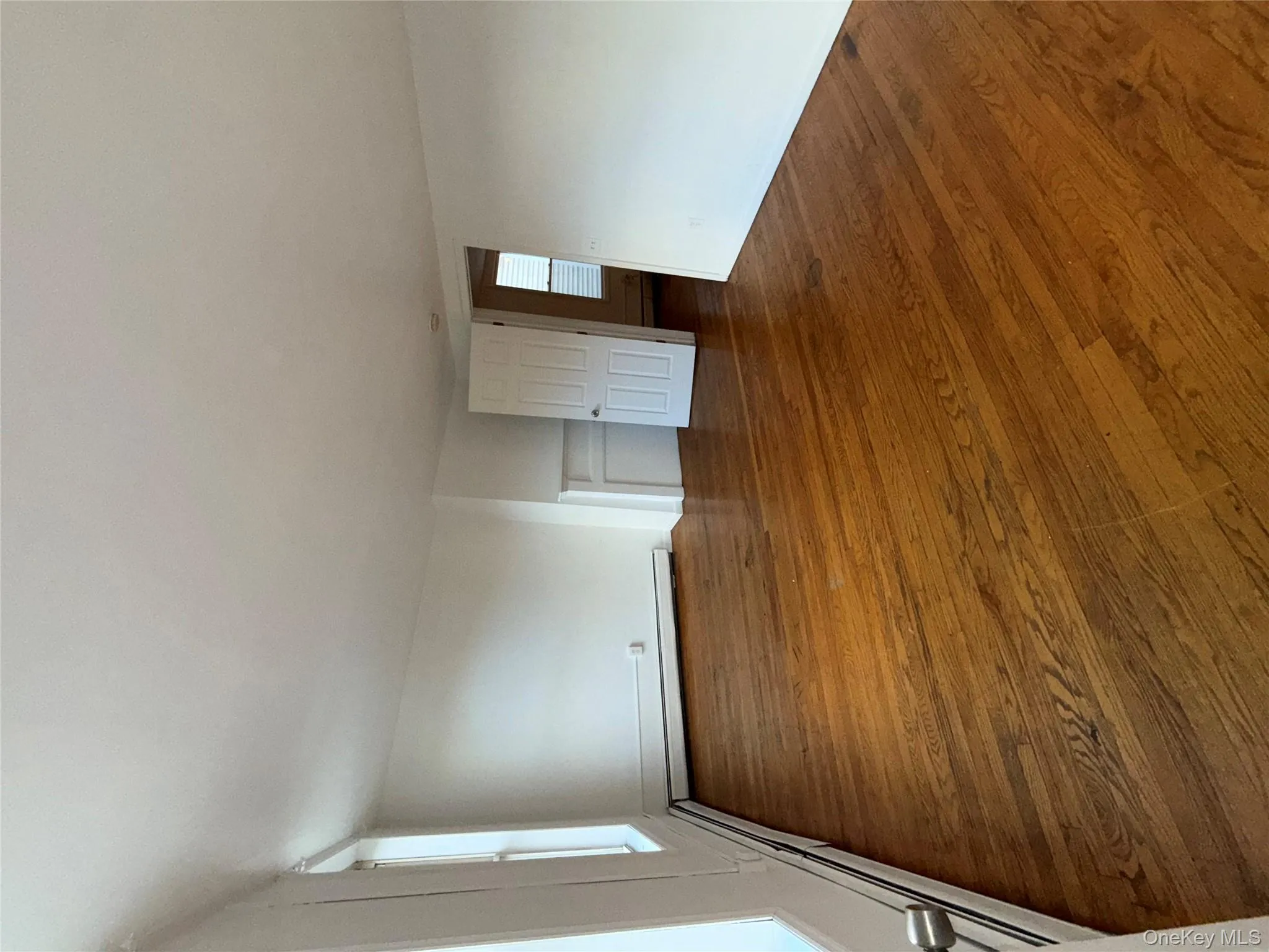 Empty room with wood finished floors and a baseboard radiator Empty room with wood finished floors and a baseboard radiator