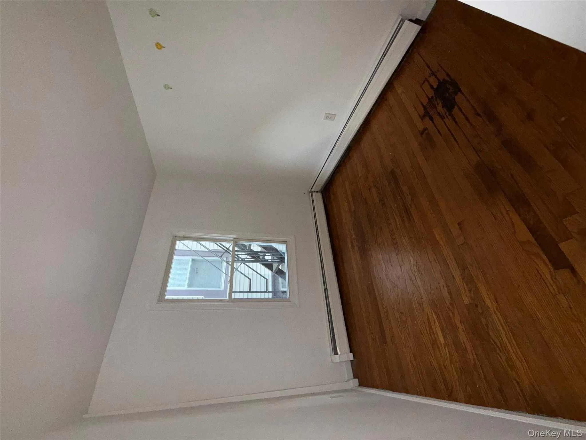 Unfurnished room with dark wood-style flooring and baseboard heating Unfurnished room with dark wood-style flooring and baseboard heating