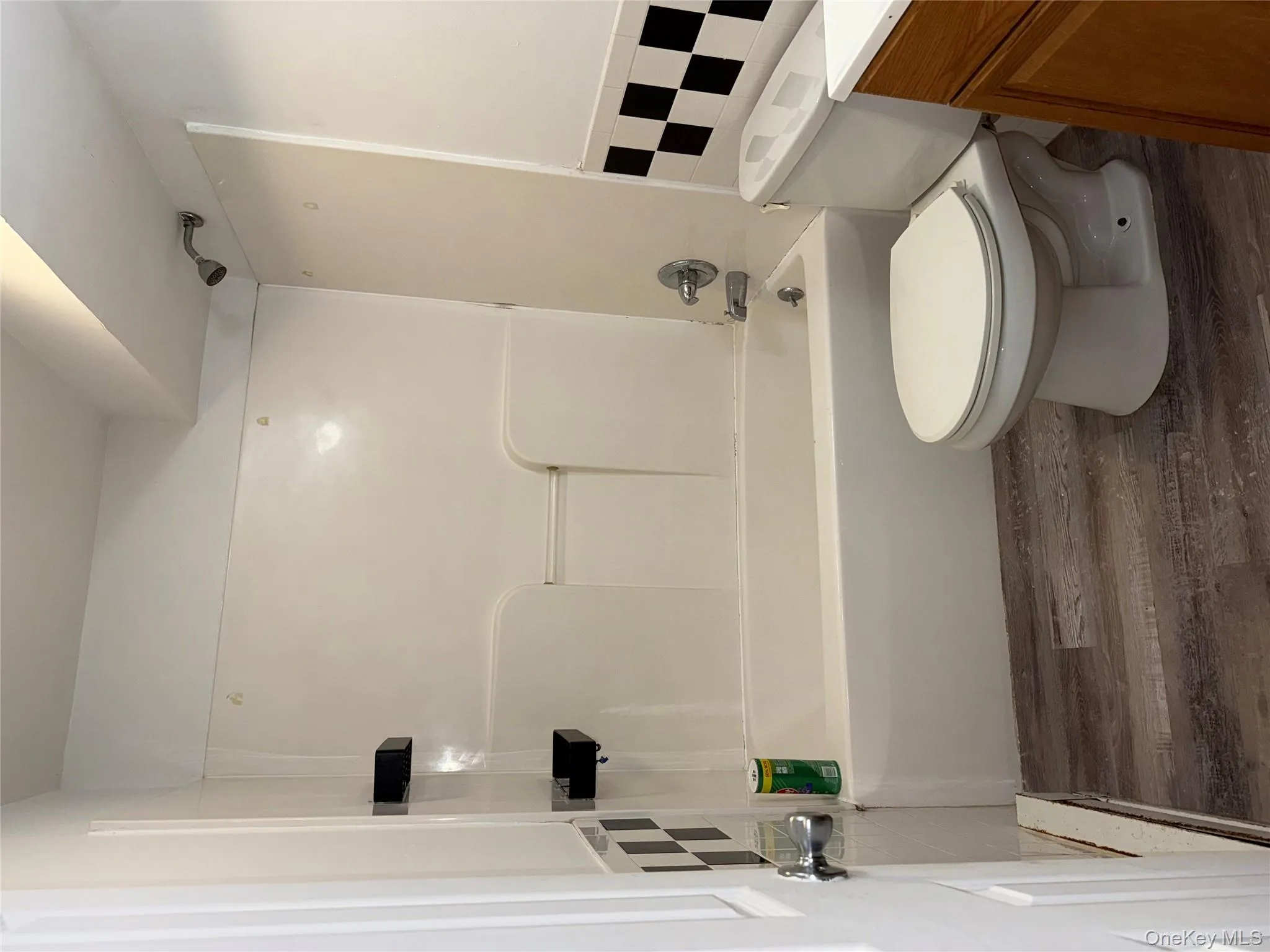 Full bath featuring dark wood-style flooring, vanity, tub / shower combination, and tile walls Full bath featuring dark wood-style flooring, vanity, tub / shower combination, and tile walls