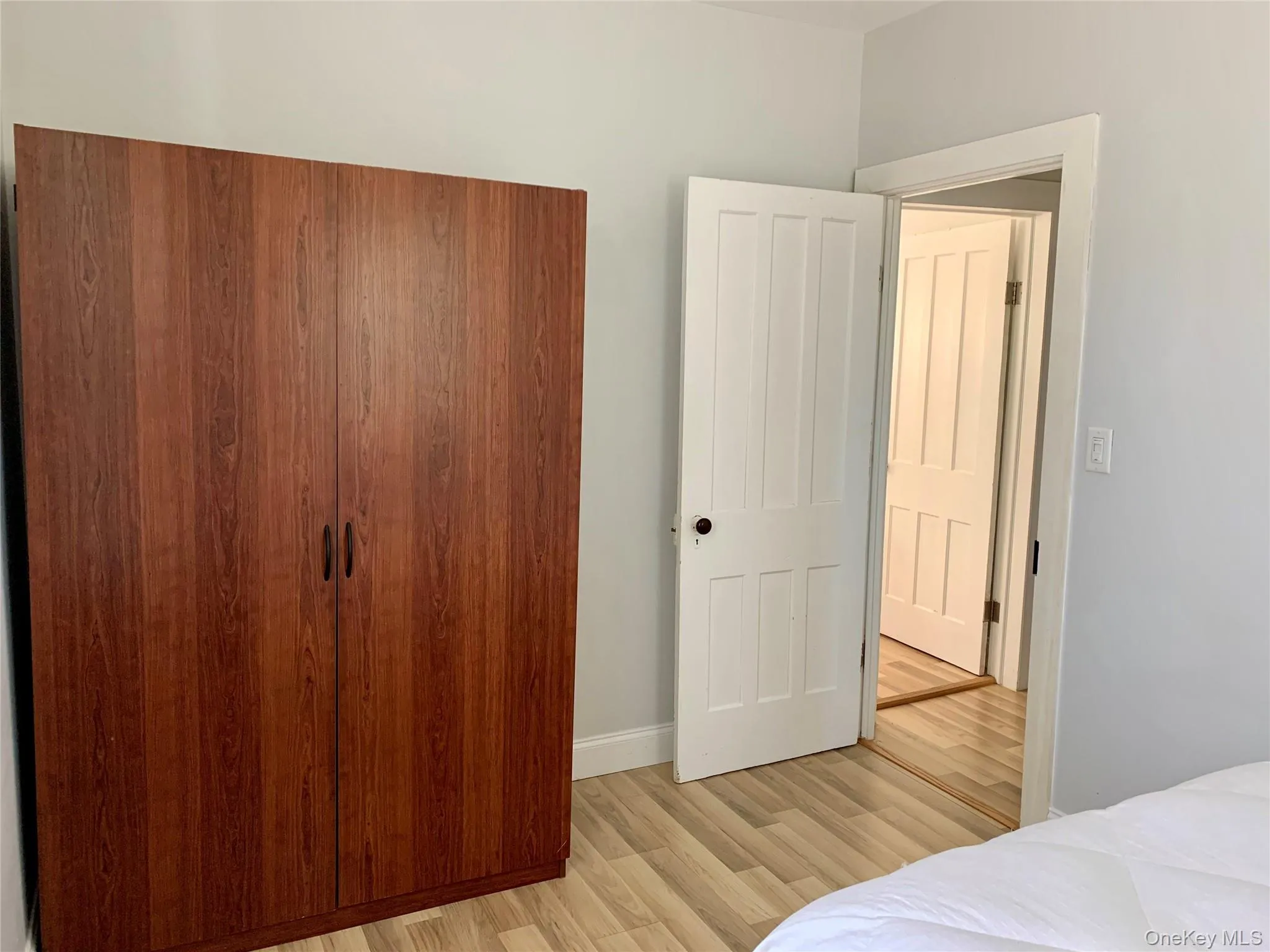 Bedroom with light wood-style flooring and baseboards Bedroom with light wood-style flooring and baseboards