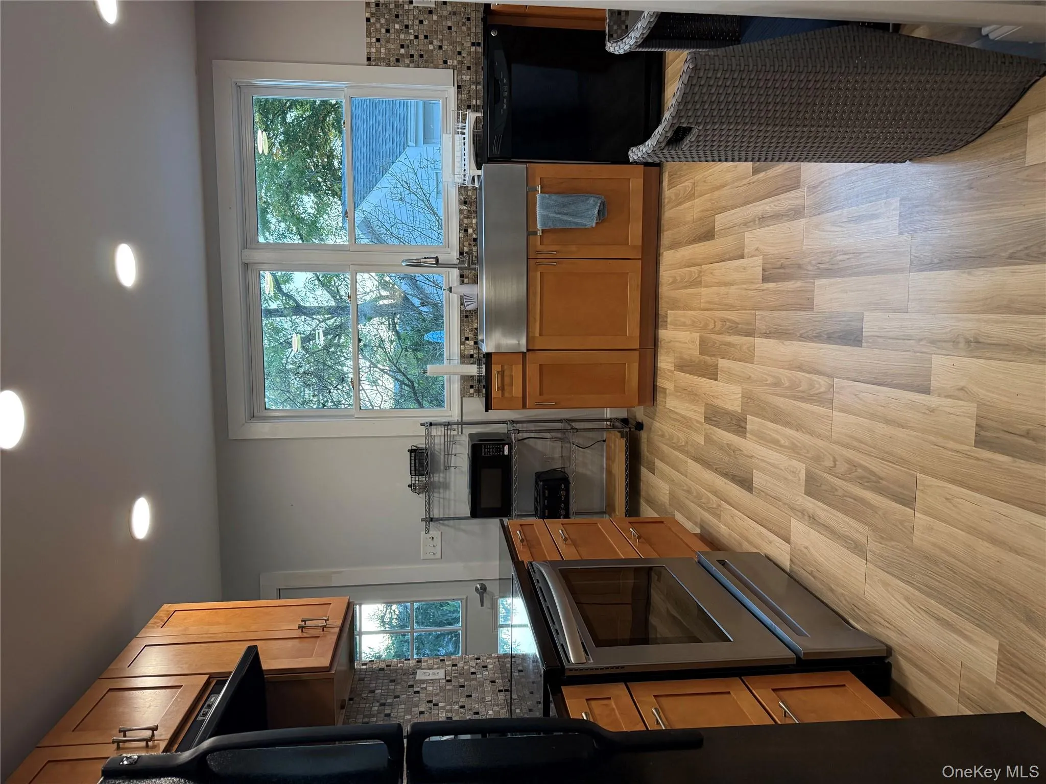 Kitchen featuring decorative backsplash, brown cabinets, healthy amount of natural light, range, and recessed lighting Kitchen featuring decorative backsplash, brown cabinets, healthy amount of natural light, range, and recessed lighting