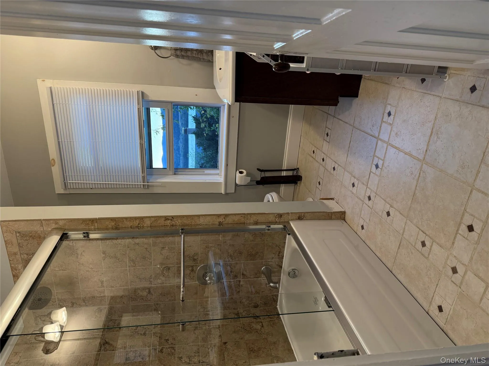 Bathroom with vanity, enclosed tub / shower combo, and light tile patterned floors Bathroom with vanity, enclosed tub / shower combo, and light tile patterned floors