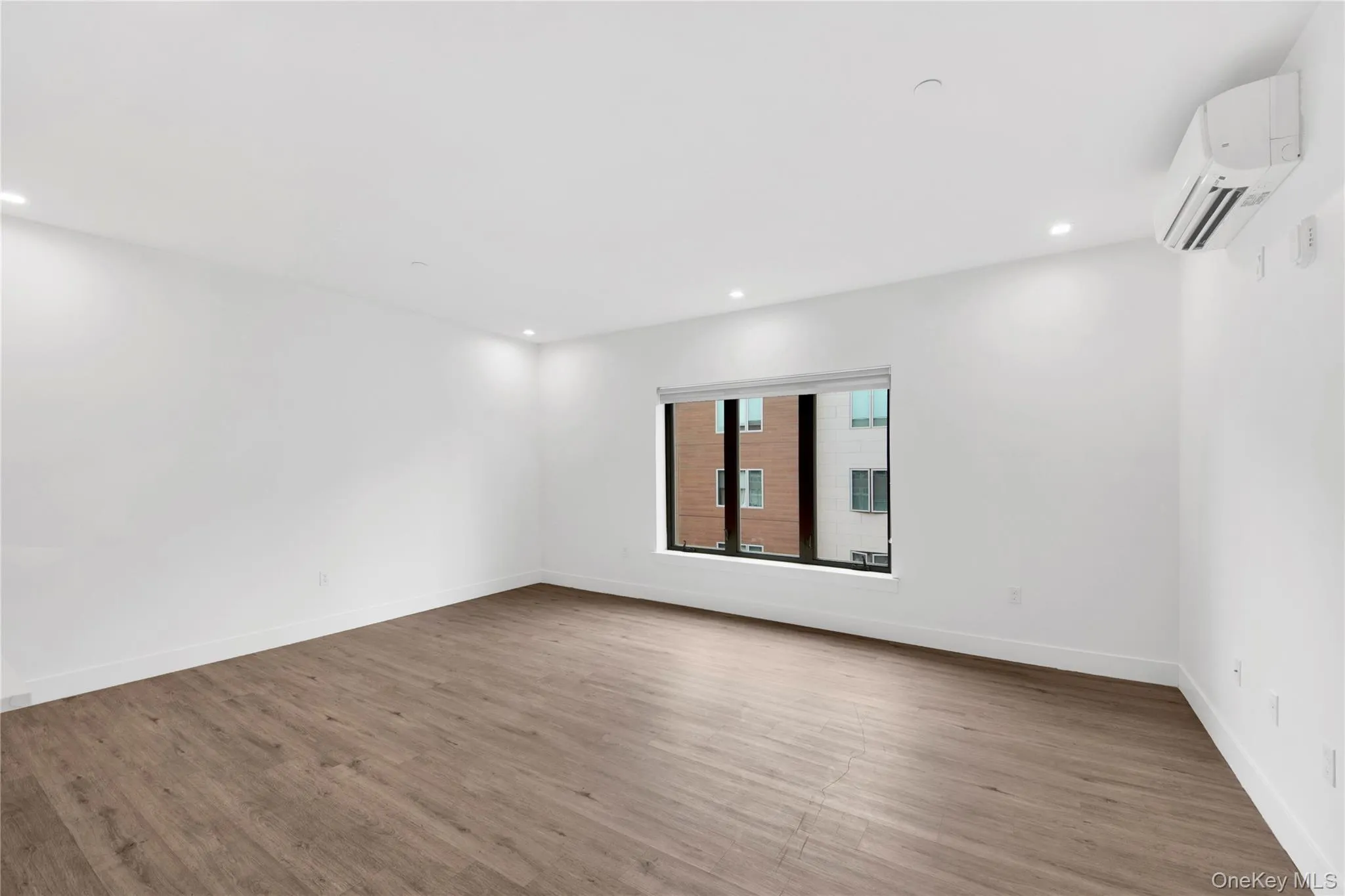 Unfurnished room featuring light wood-style flooring, an AC wall unit, and recessed lighting Unfurnished room featuring light wood-style flooring, an AC wall unit, and recessed lighting