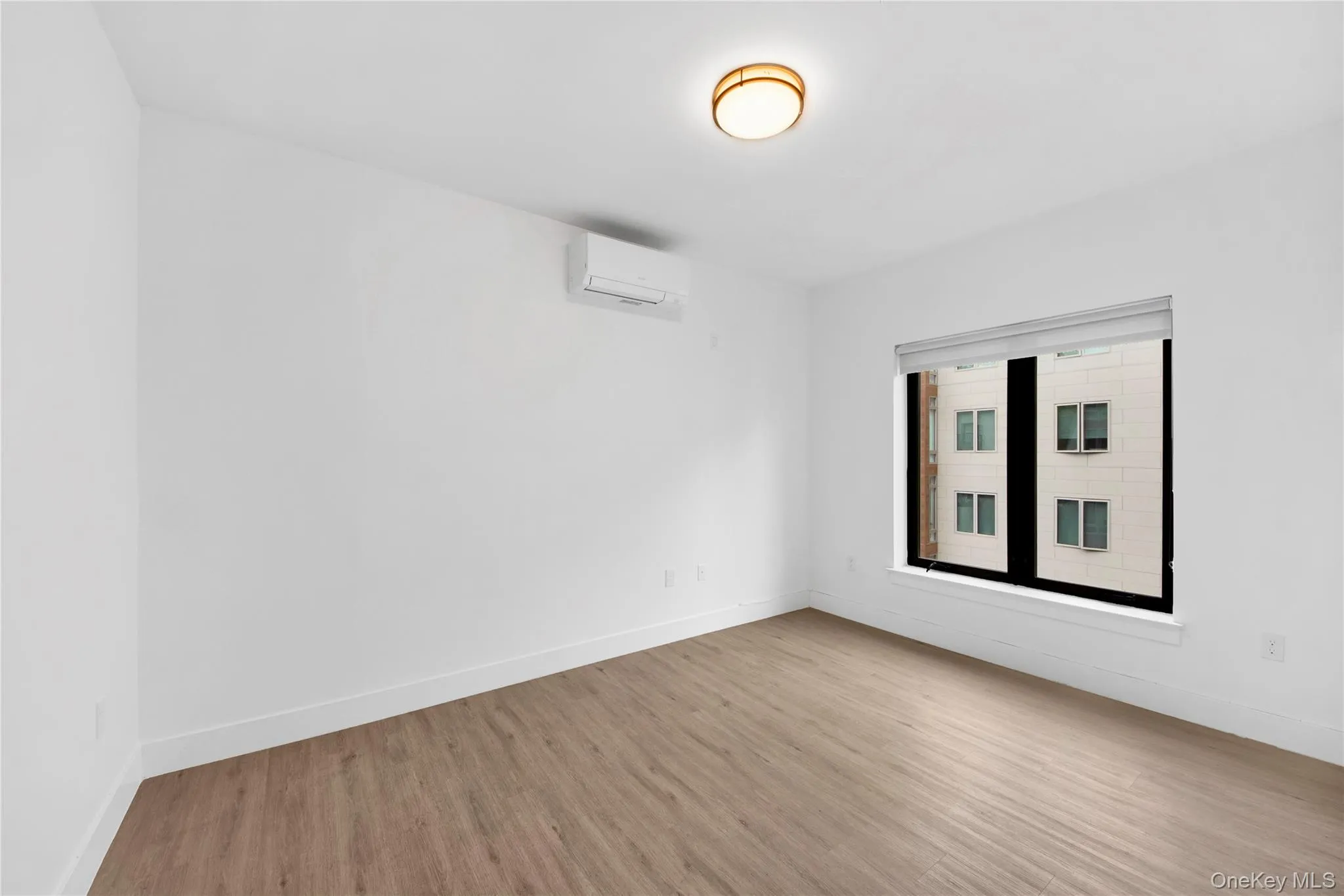 Empty room featuring wood finished floors and a wall unit AC Empty room featuring wood finished floors and a wall unit AC